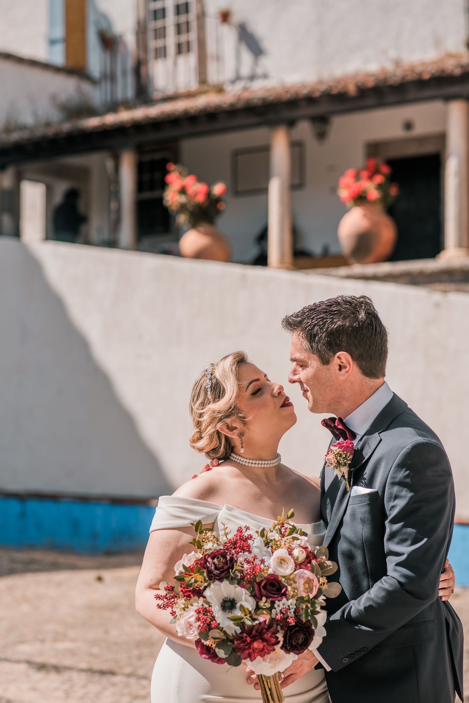 Bride and groom embracing in the historic streets of Óbidos during a destination wedding in Portugal.