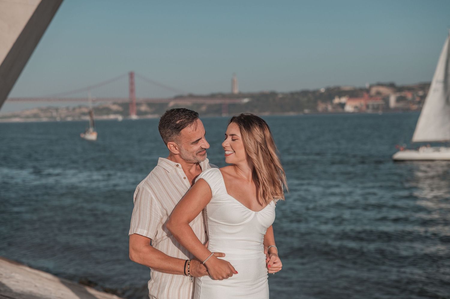 Engaged couple sharing an intimate moment in Belém, Lisbon, outdoor photography.