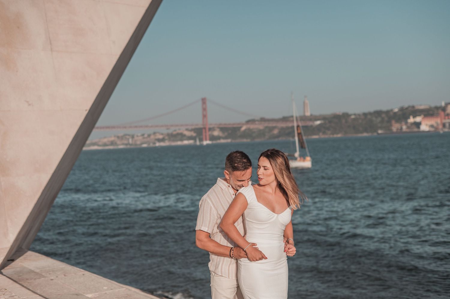 Engaged couple sharing an intimate moment in Belém, Lisbon, outdoor photography.