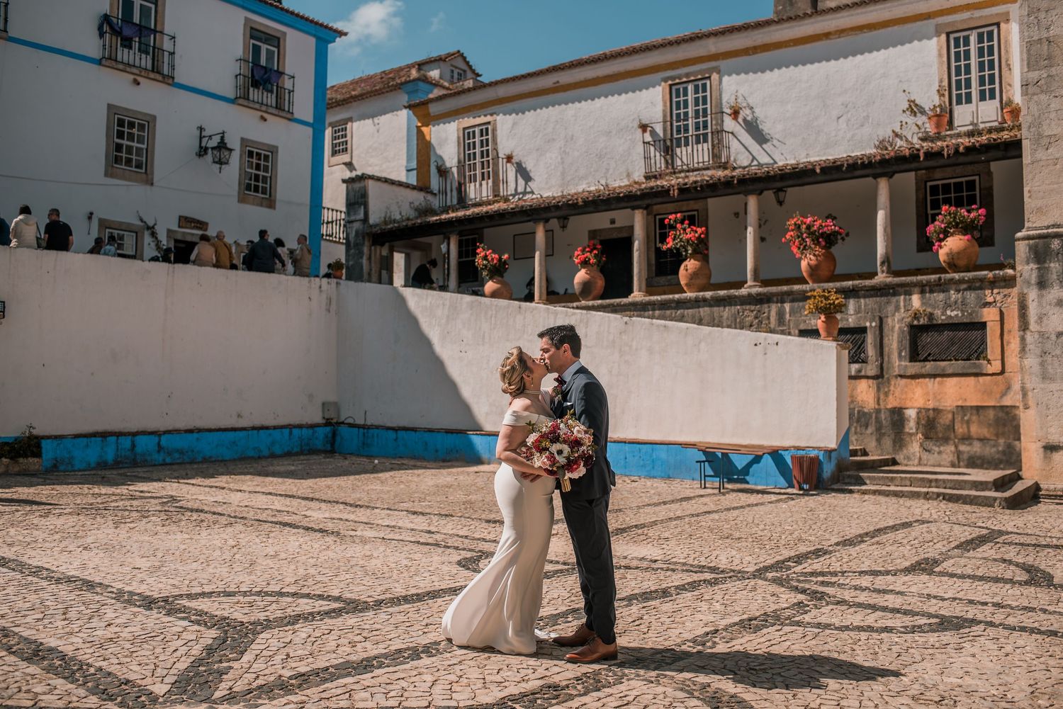 Bride and groom embracing in the historic streets of Óbidos during a destination wedding in Portugal.