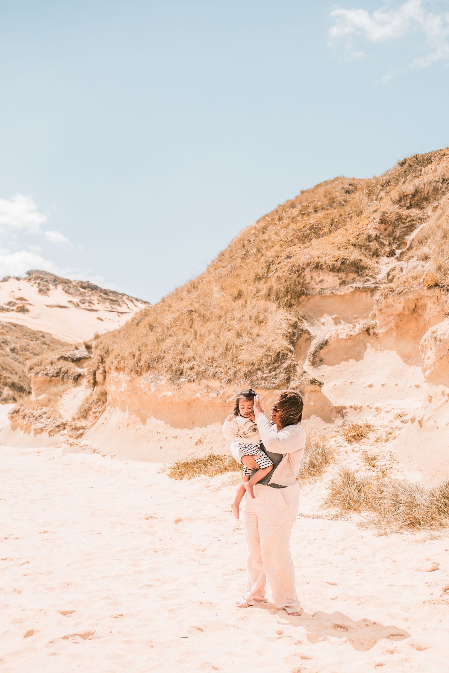 Parents and children playing together on a sandy beach in Portugal.