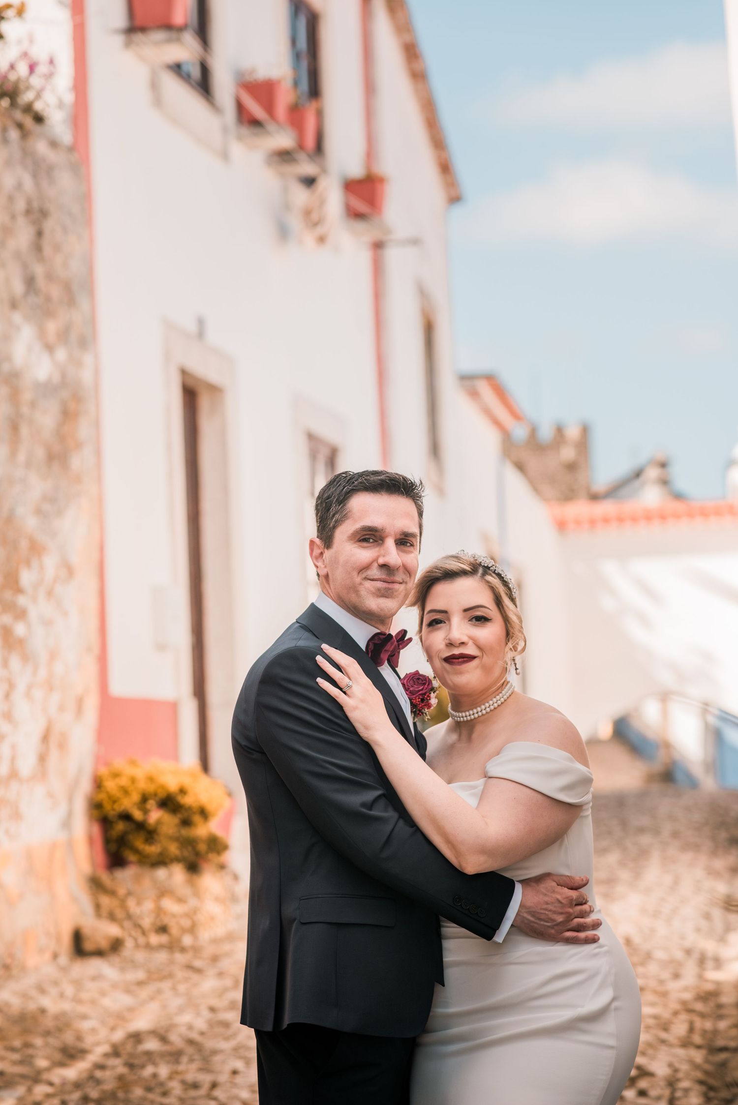 Bride and groom embracing in the historic streets of Óbidos during a destination wedding in Portugal.