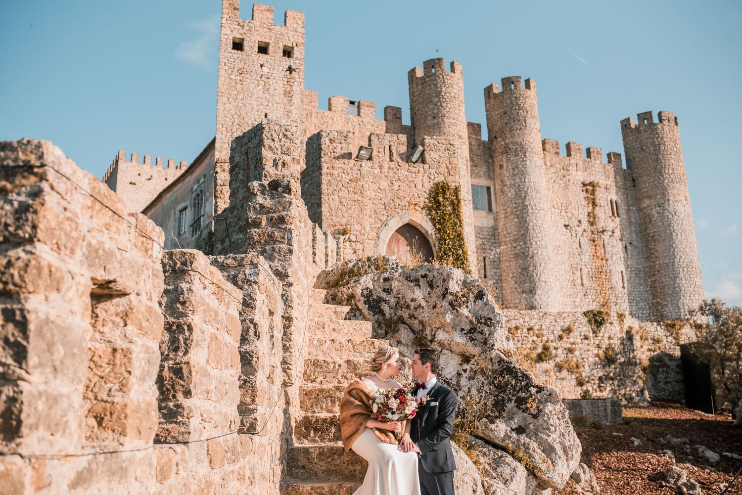 Natural and emotional wedding photography in Óbidos with soft light and historic architecture.