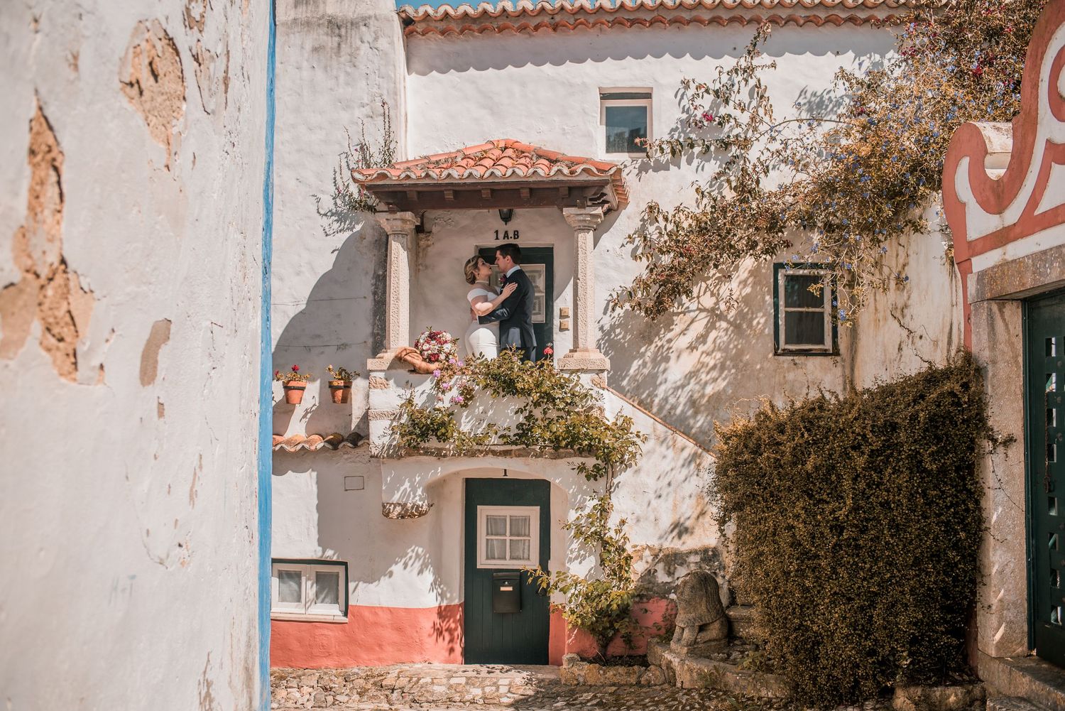 Bride and groom embracing in the historic streets of Óbidos during a destination wedding in Portugal.