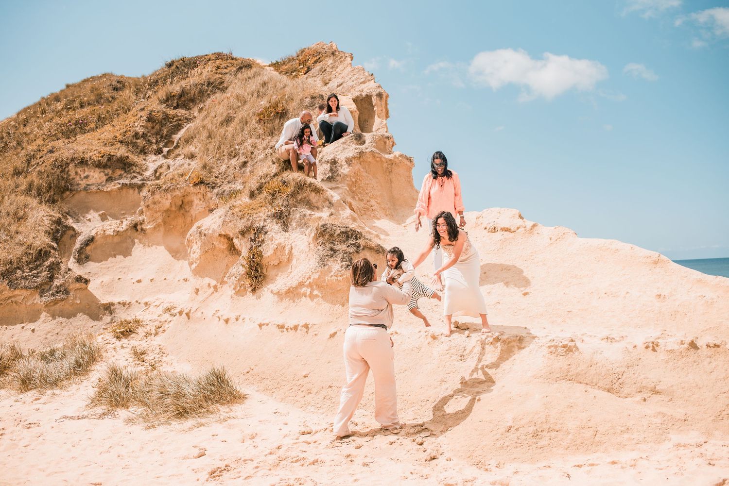 Parents and children playing together on a sandy beach in Portugal.