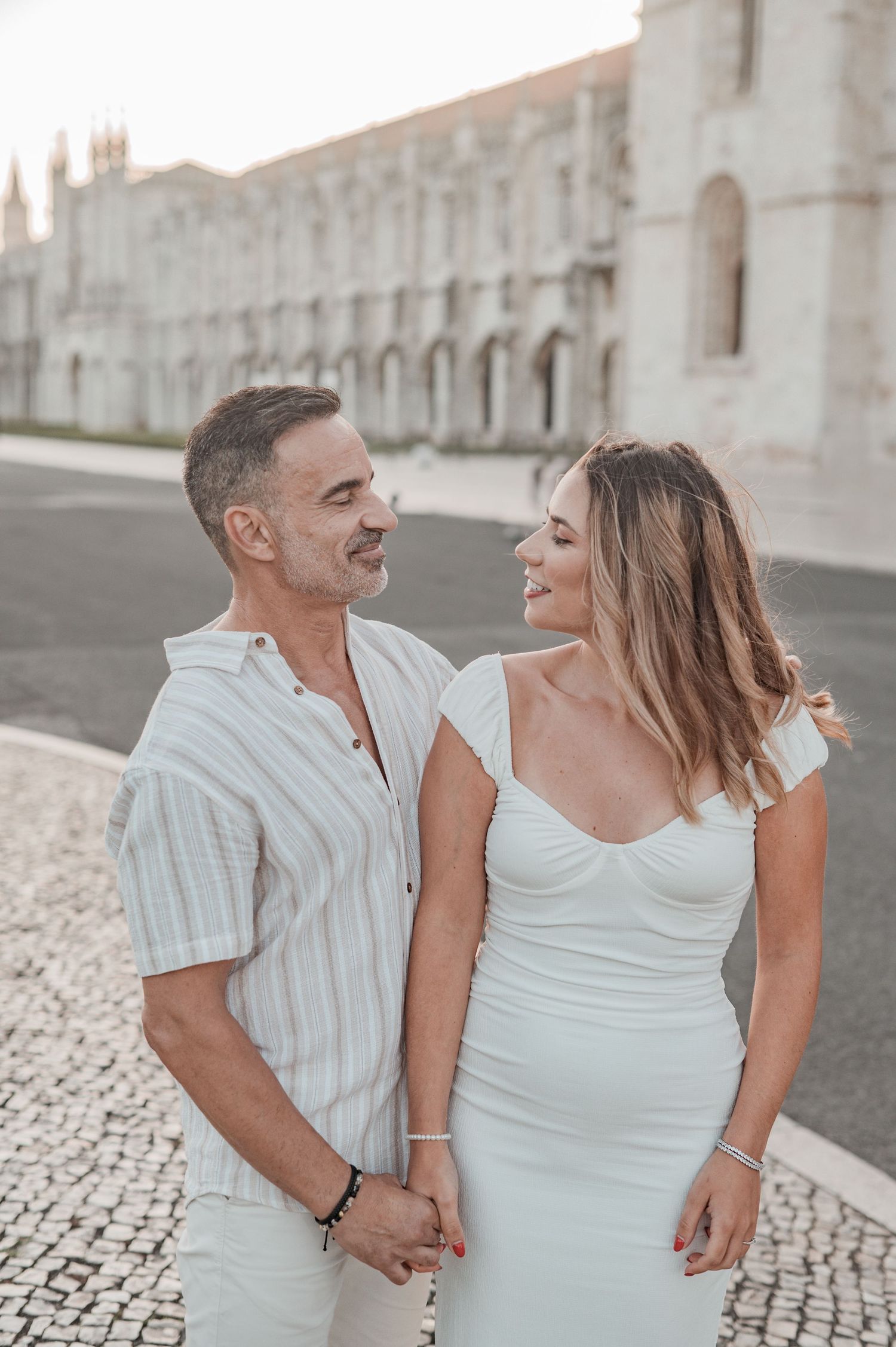 Engagement photography in Belém, Lisbon, capturing a couple walking hand in hand.