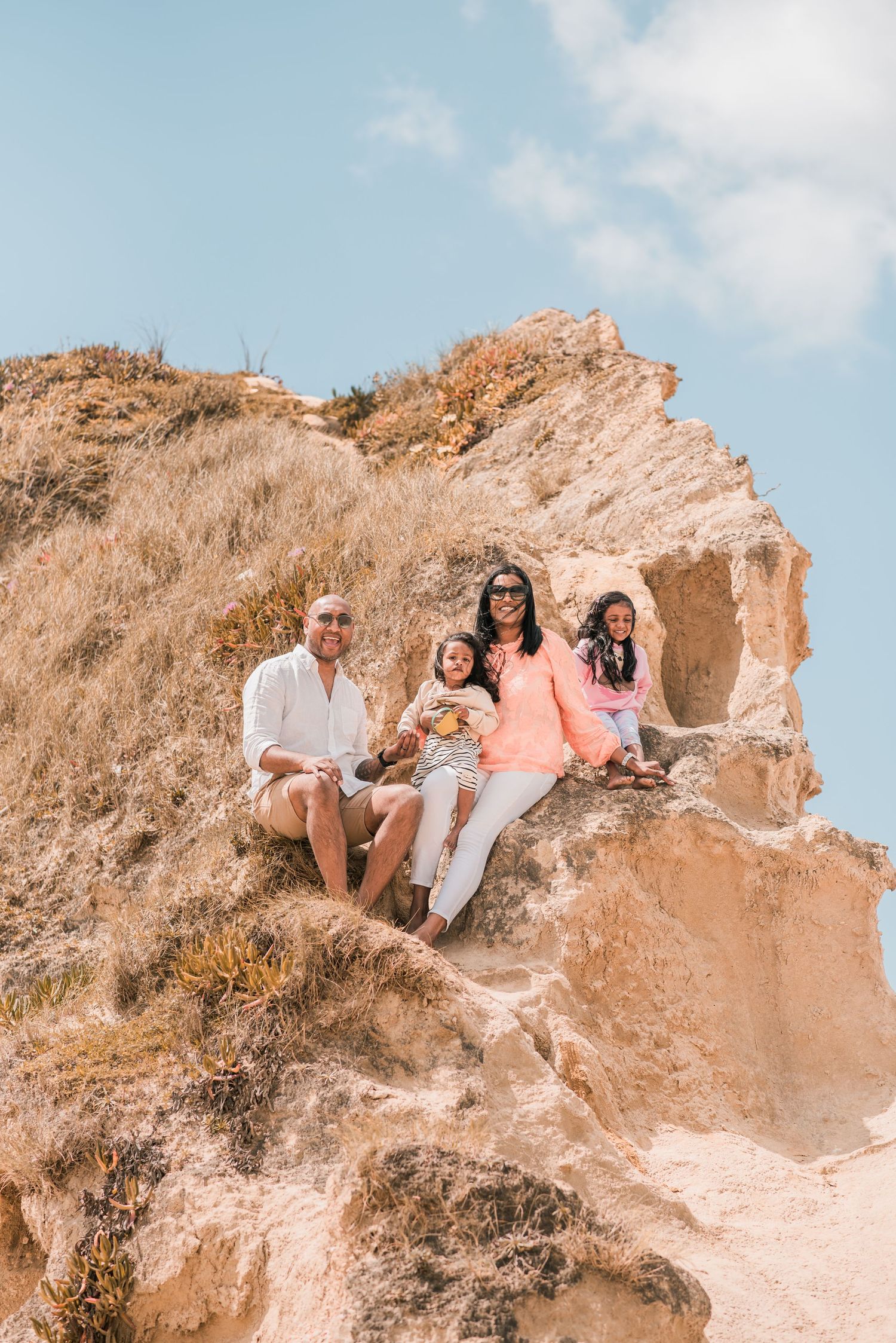 Parents and children playing together on a sandy beach in Portugal.