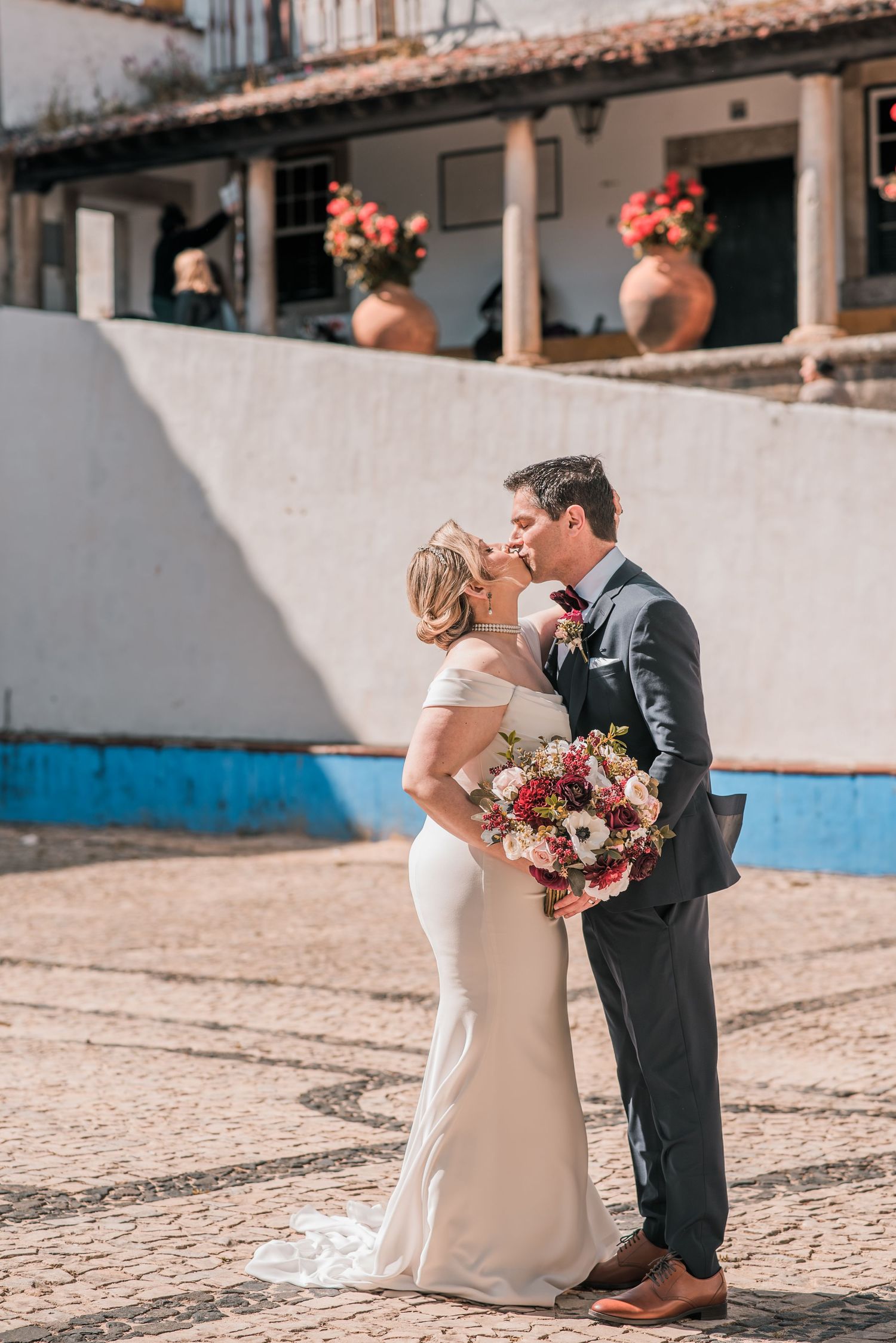 Bride and groom embracing in the historic streets of Óbidos during a destination wedding in Portugal.