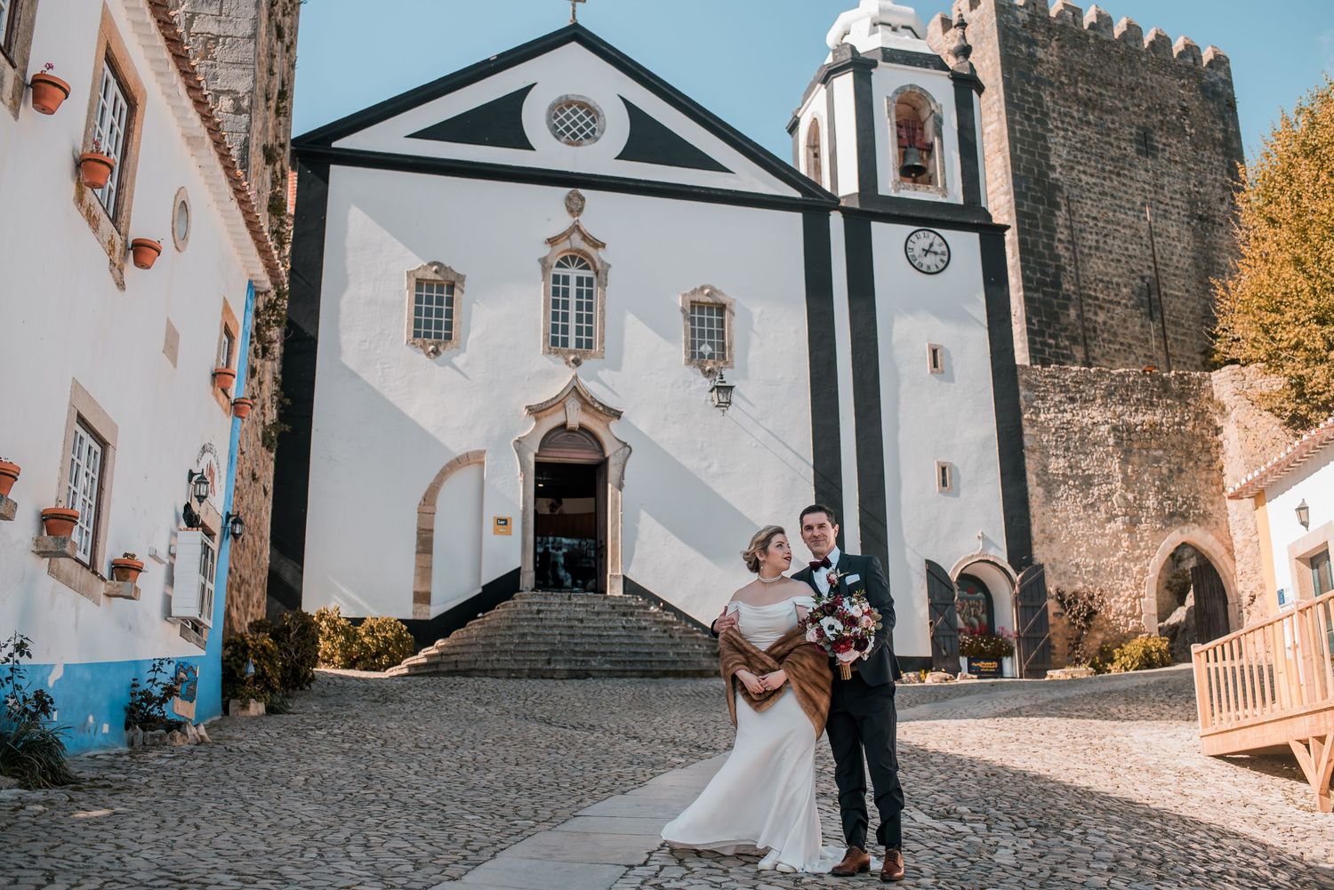 Natural and emotional wedding photography in Óbidos with soft light and historic architecture.