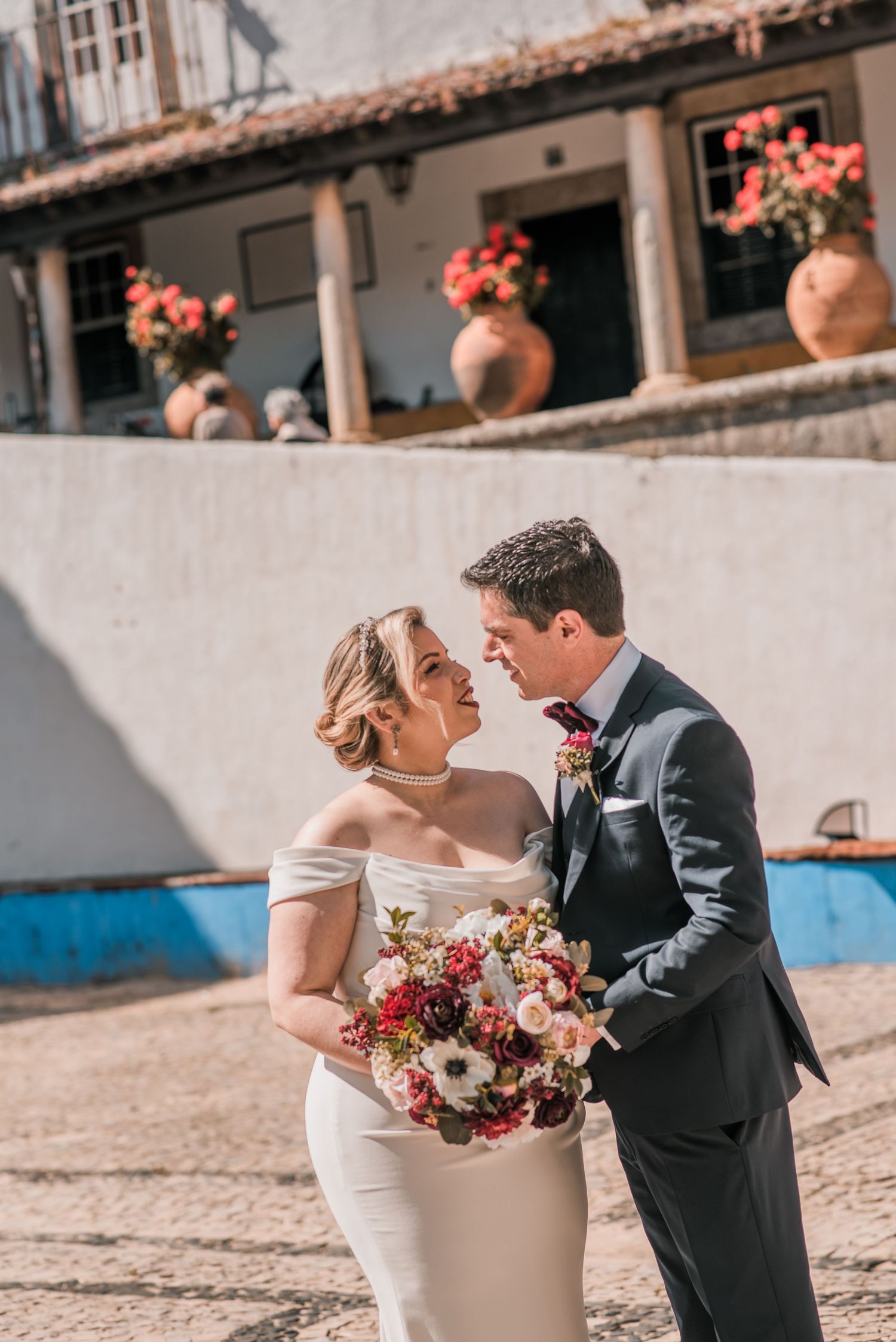 Bride and groom embracing in the historic streets of Óbidos during a destination wedding in Portugal.
