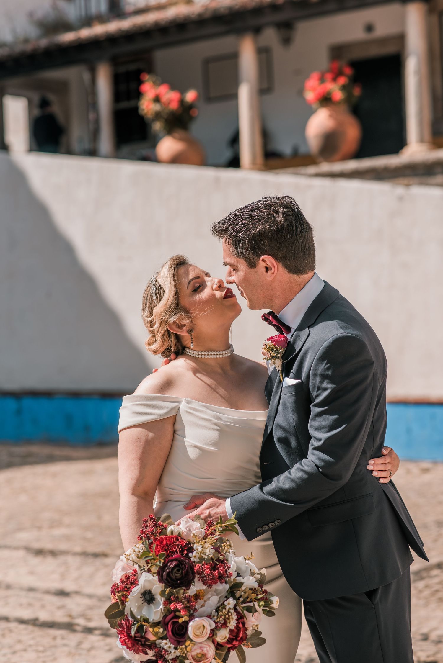 Bride and groom embracing in the historic streets of Óbidos during a destination wedding in Portugal.