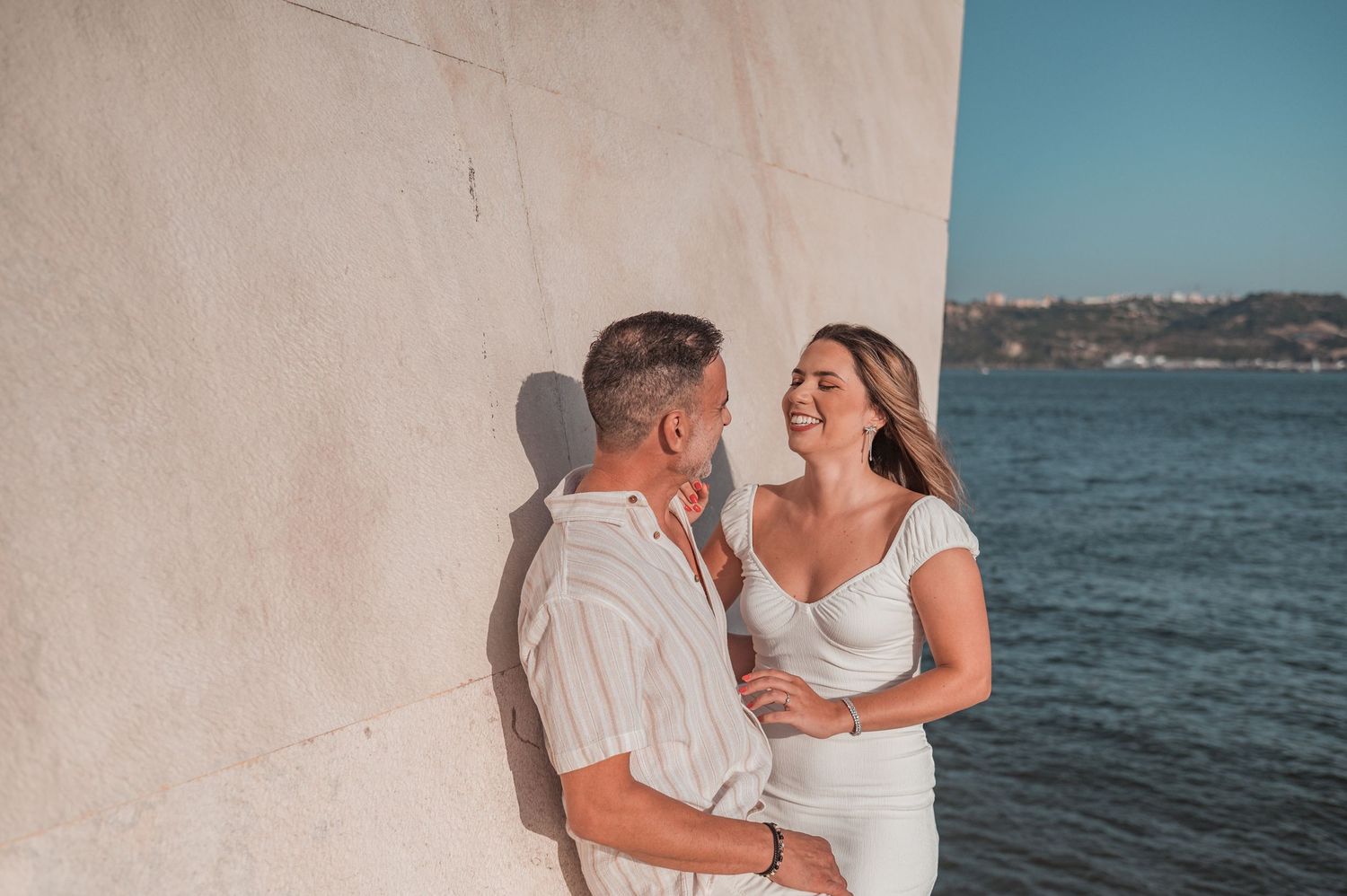 Engaged couple sharing an intimate moment in Belém, Lisbon, outdoor photography.