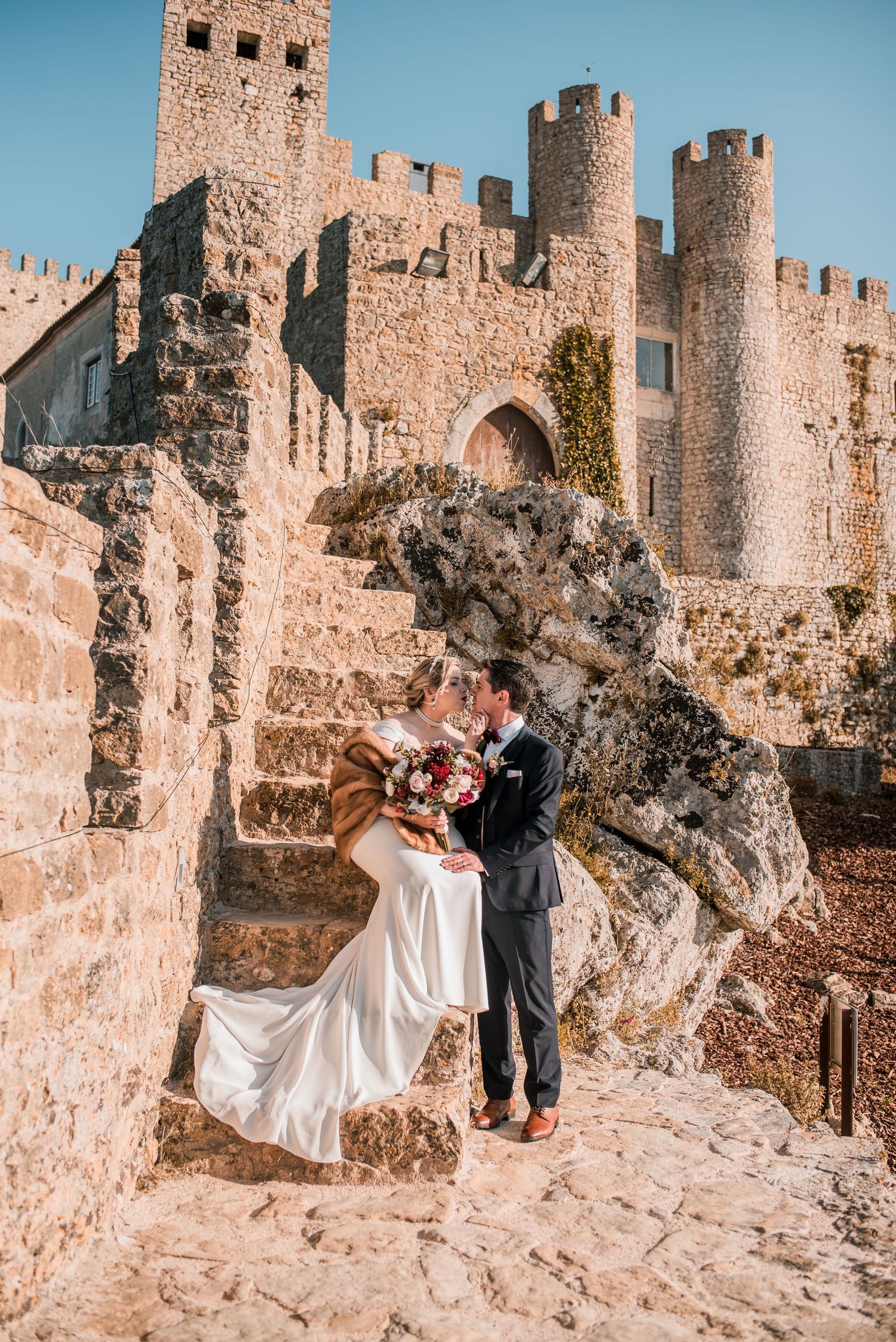 Natural and emotional wedding photography in Óbidos with soft light and historic architecture.
