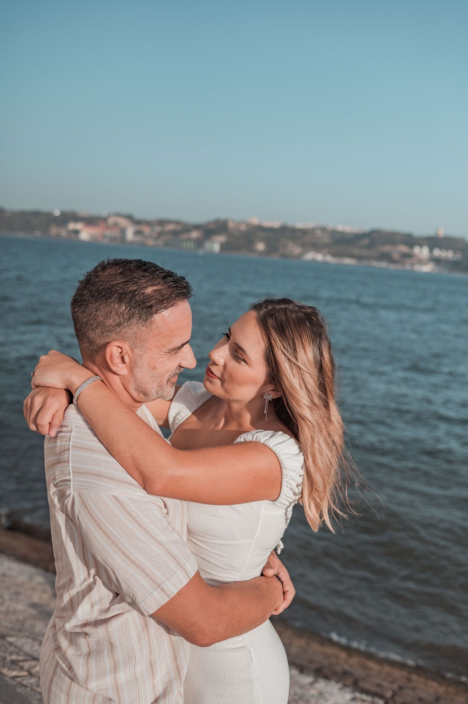 Engaged couple sharing an intimate moment in Belém, Lisbon, outdoor photography.