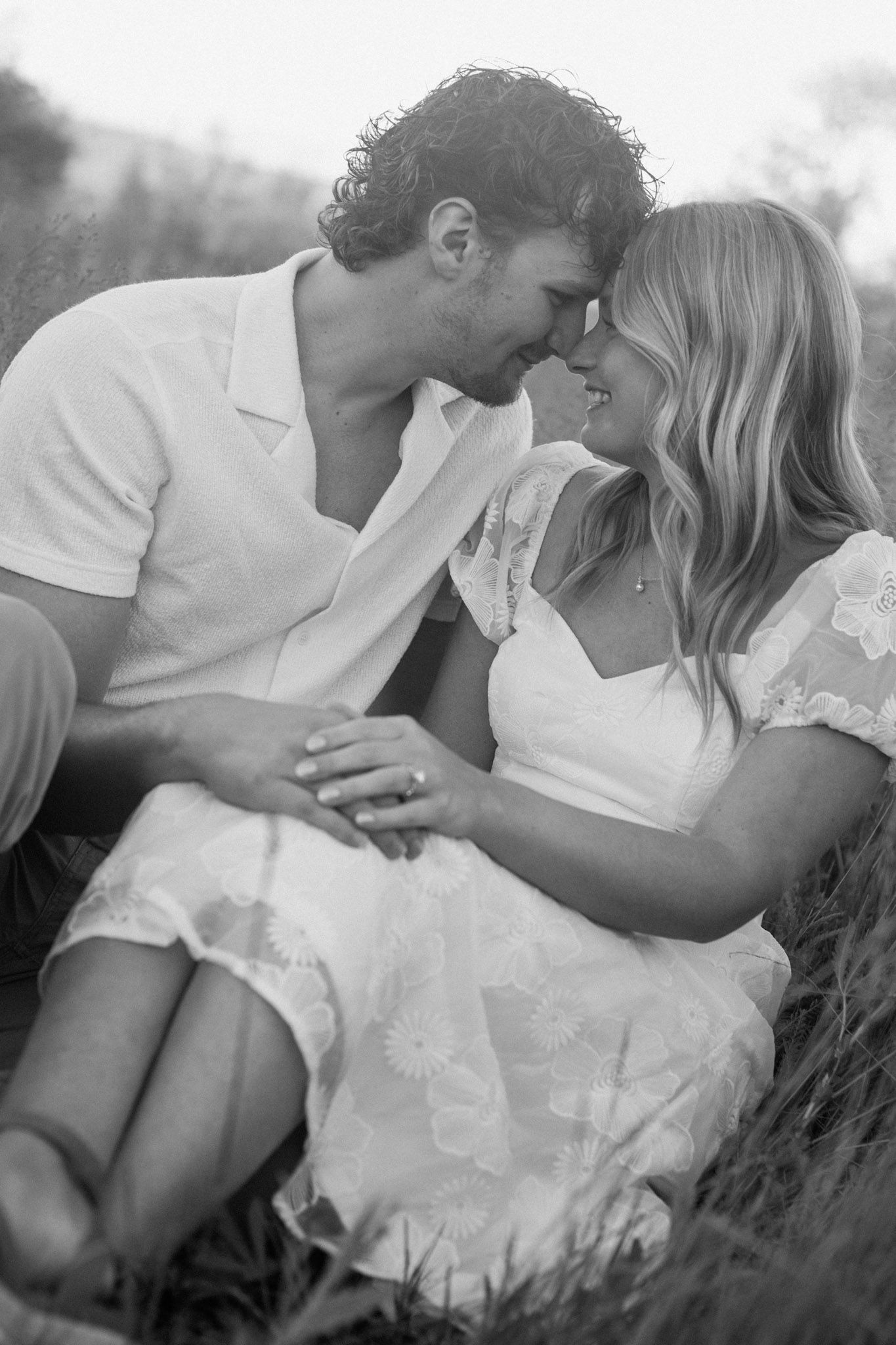 Couple embracing during their engagement session at Millenium Park in Grand Rapids, MI, in black and white.