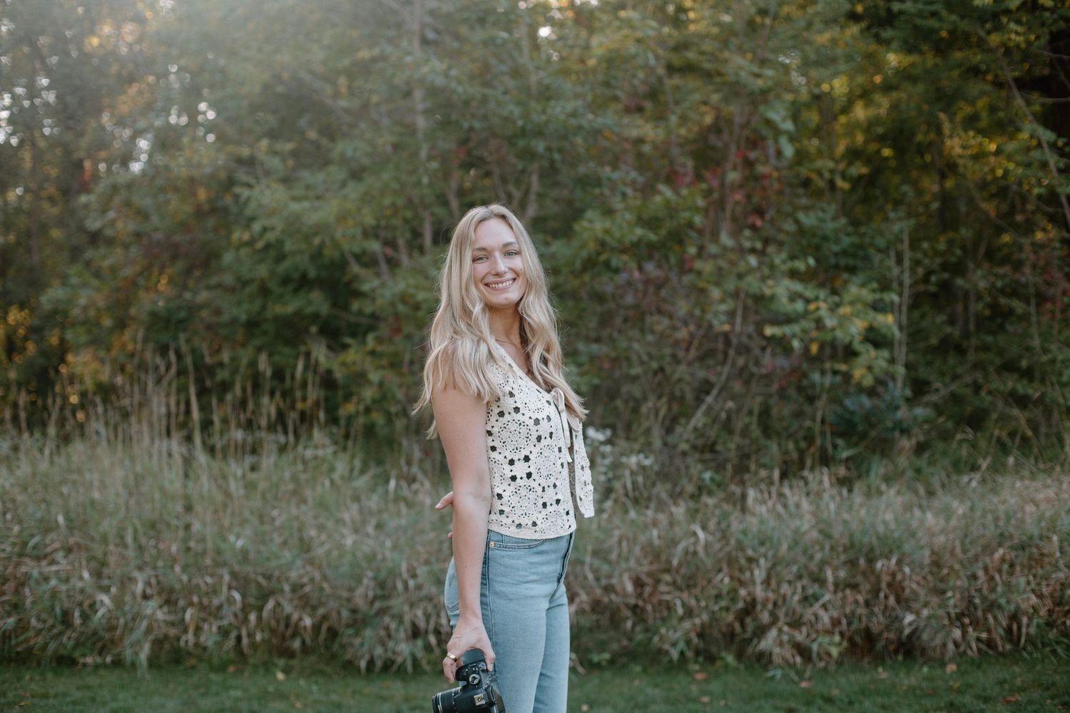 Eden, West Michigan Phorographer, with her camera at golden hour.