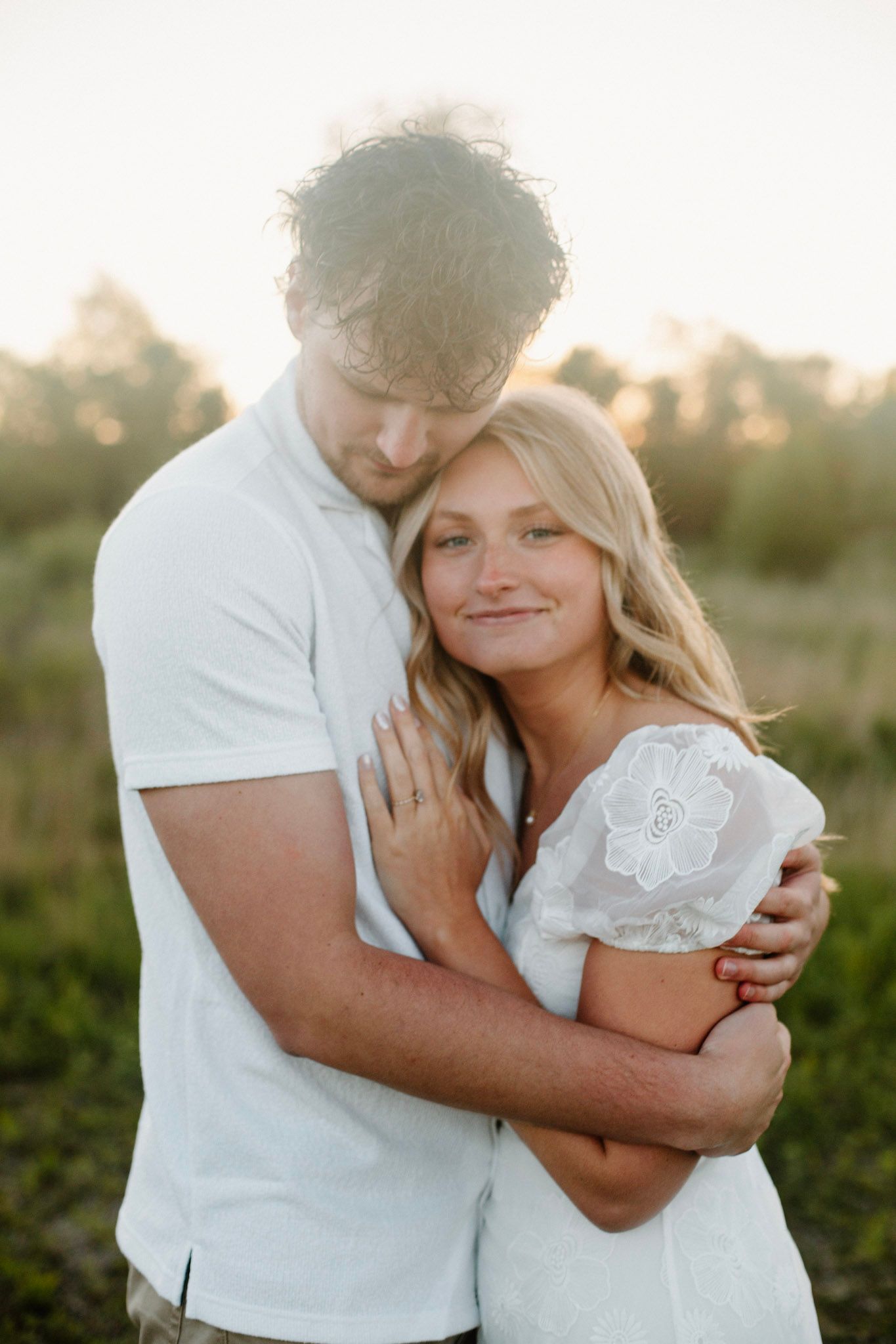 Couple embracing during their engagement session at Millenium Park in Grand Rapids, MI at golden hour.
