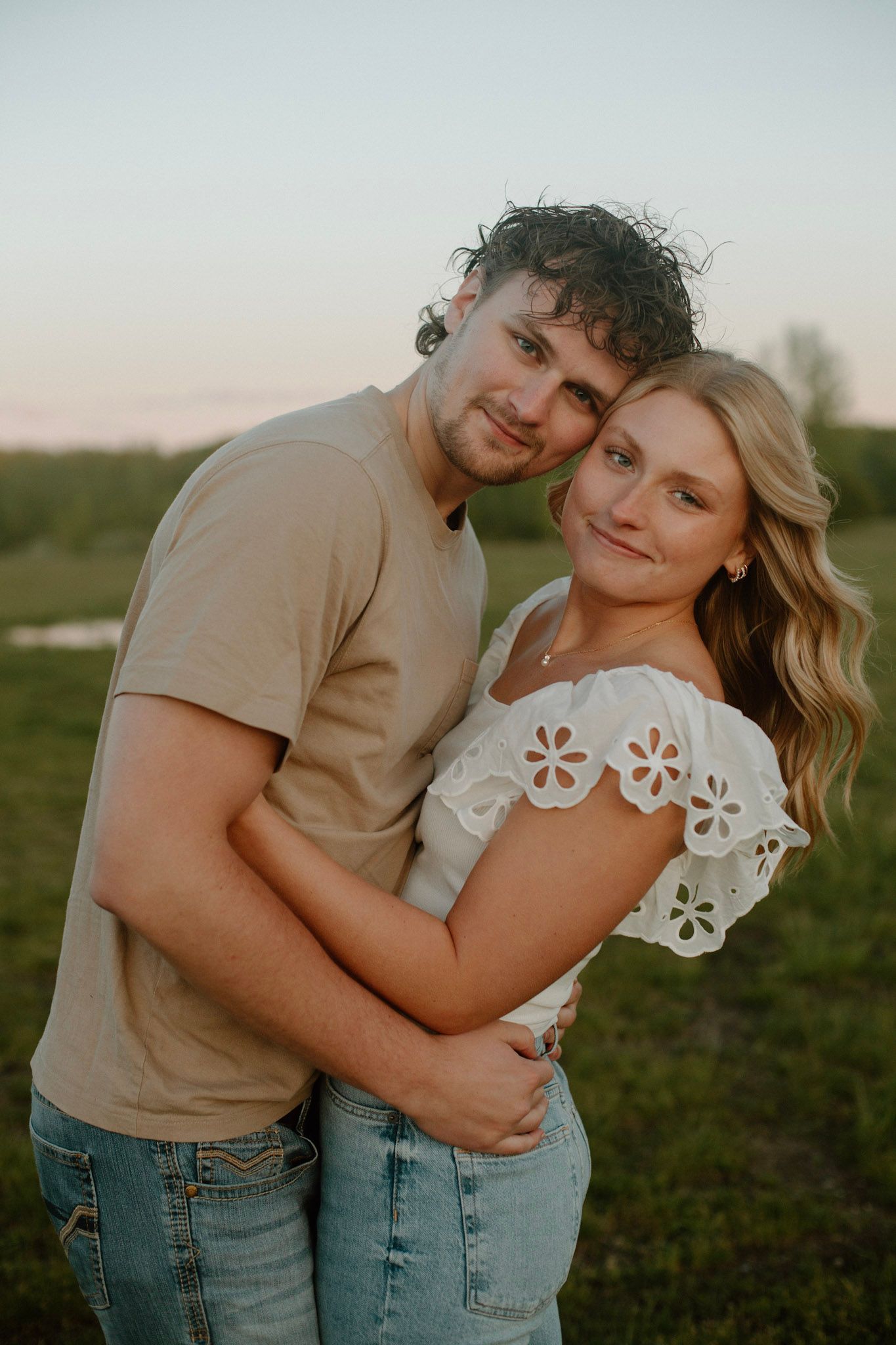 Couple embracing during their engagement session at Millenium Park in Grand Rapids, MI.