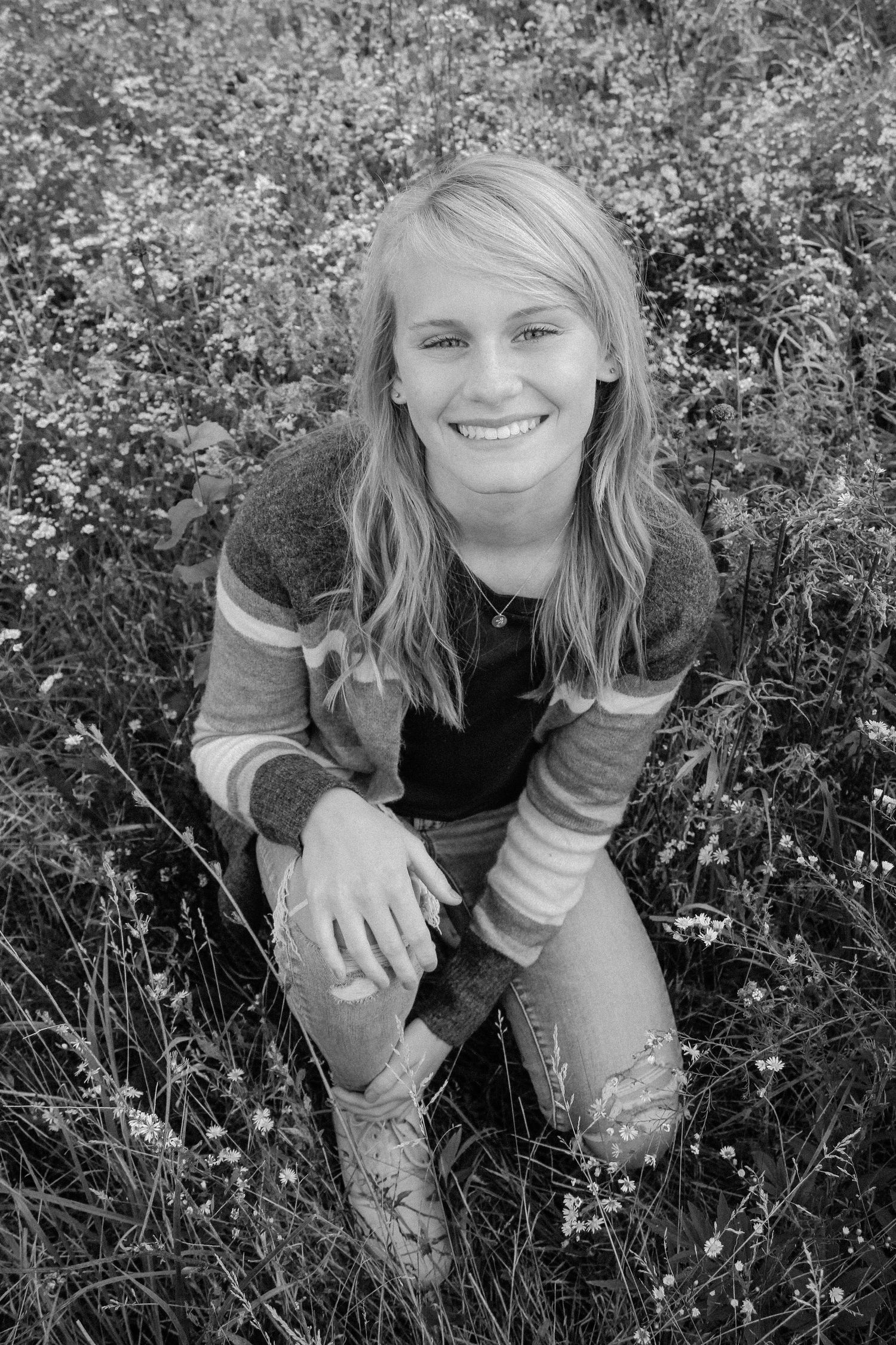 Senior girl in a field during golden hour, in black and white.