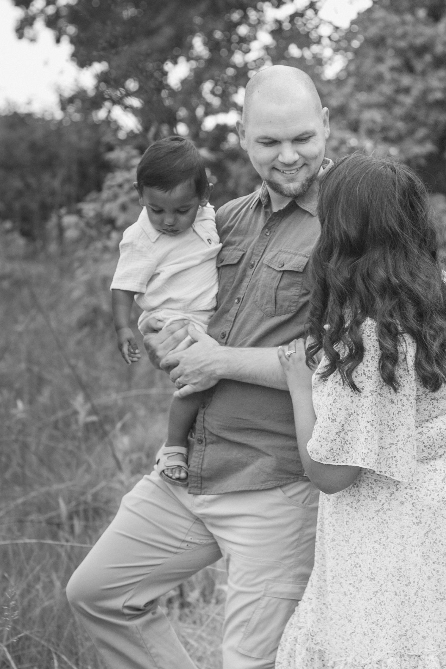 Family of three walking during their outdoor family session at Grand Ravines Park, in black and white.