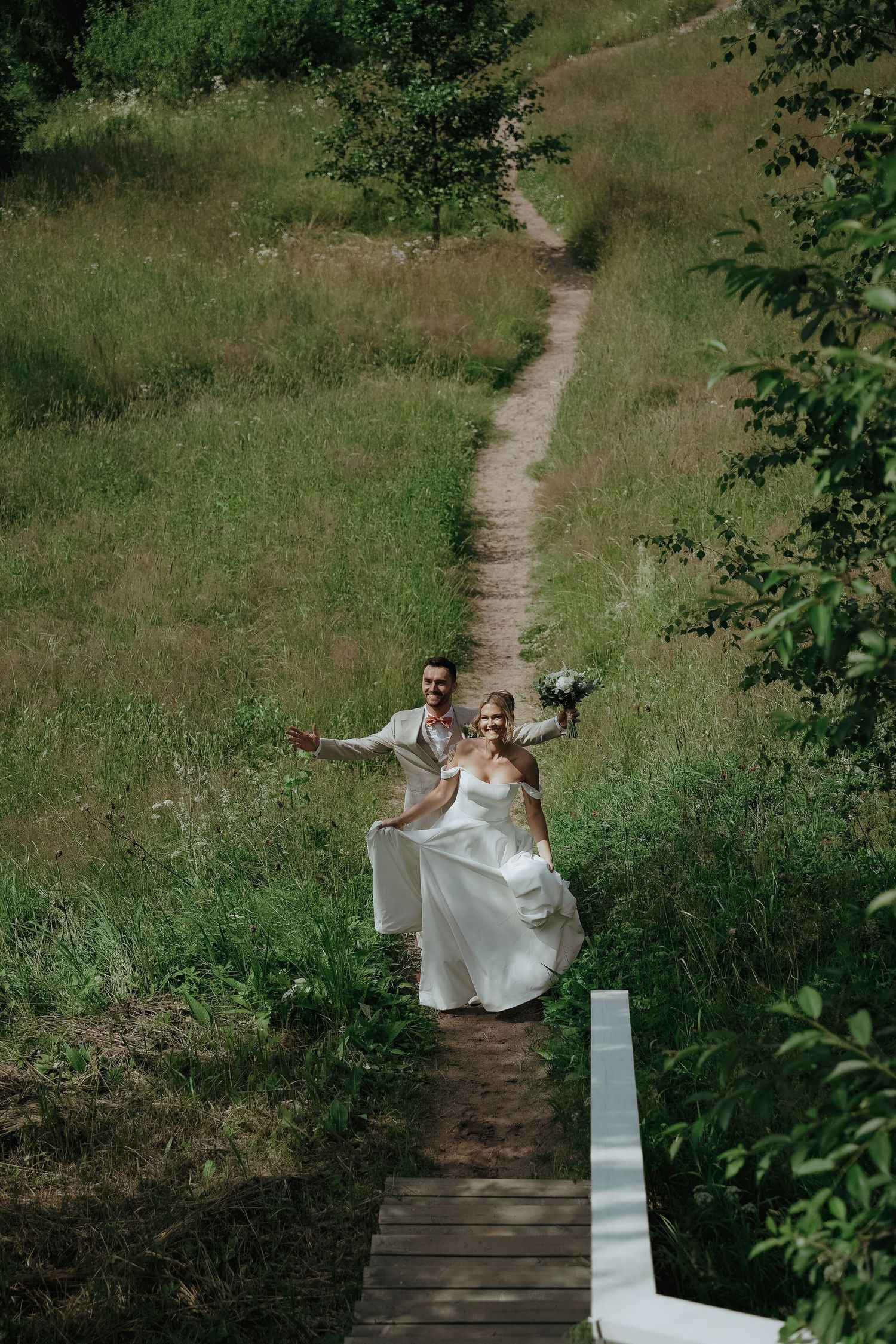 A rustic winding dirt path leads through lush green grass and foliage in a series of scenic outdoor wedding photos.