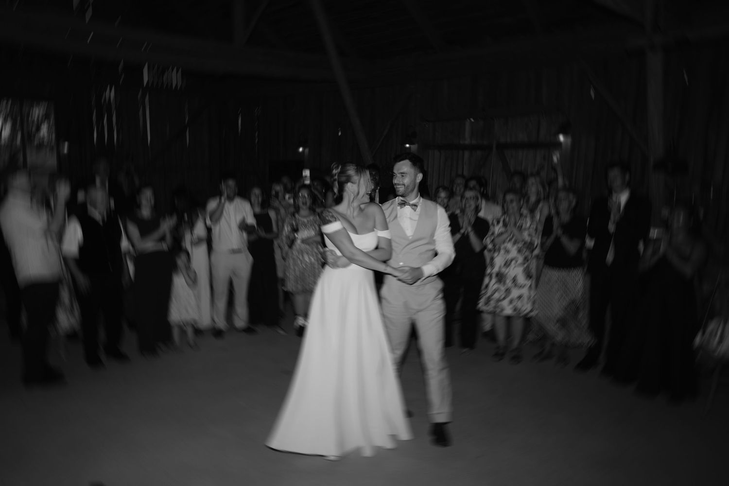A dance floor filled with couples performing traditional ballroom dancing in black and white formal attire.
