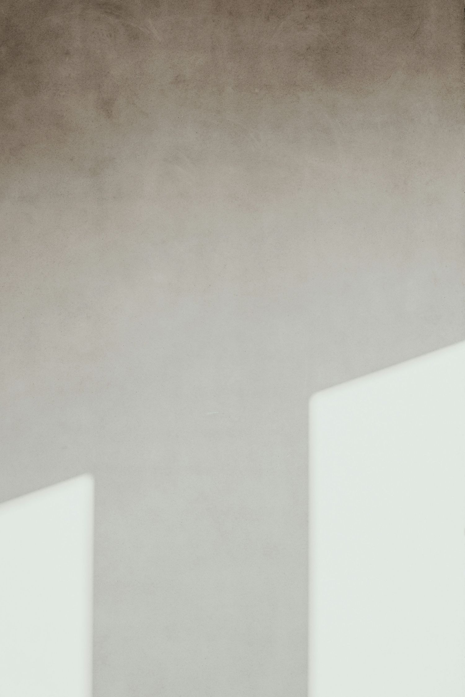 Minimalist architectural detail showing soft shadows and angles on a light gray wall.