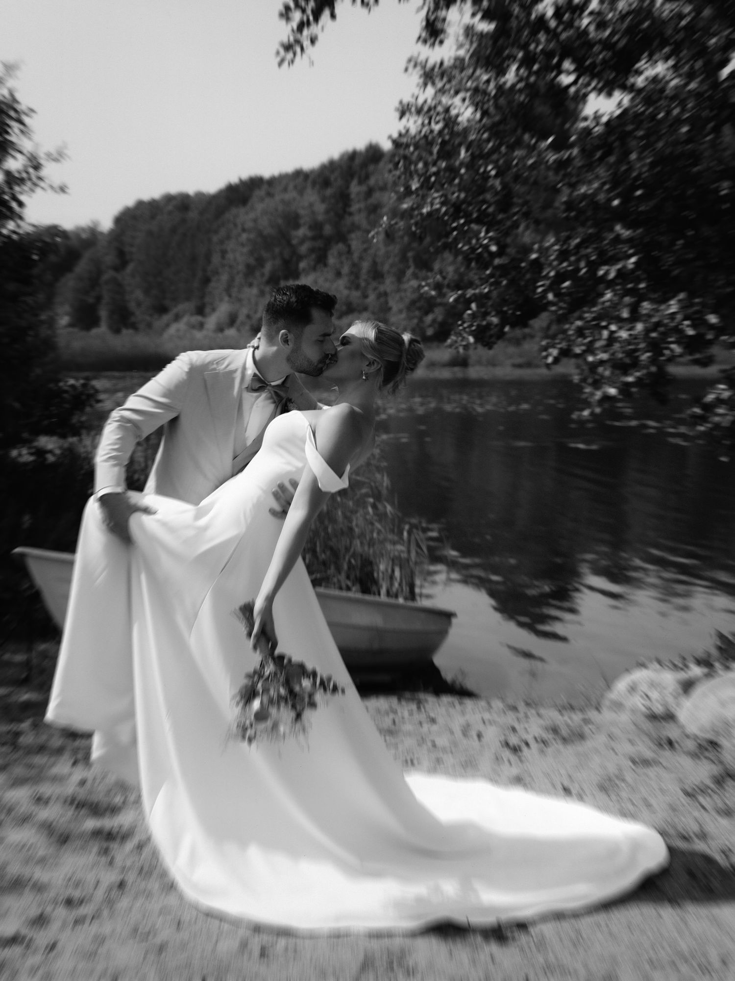 A collage of black and white photos showing a bride in a flowing white dress dancing gracefully near a lake.