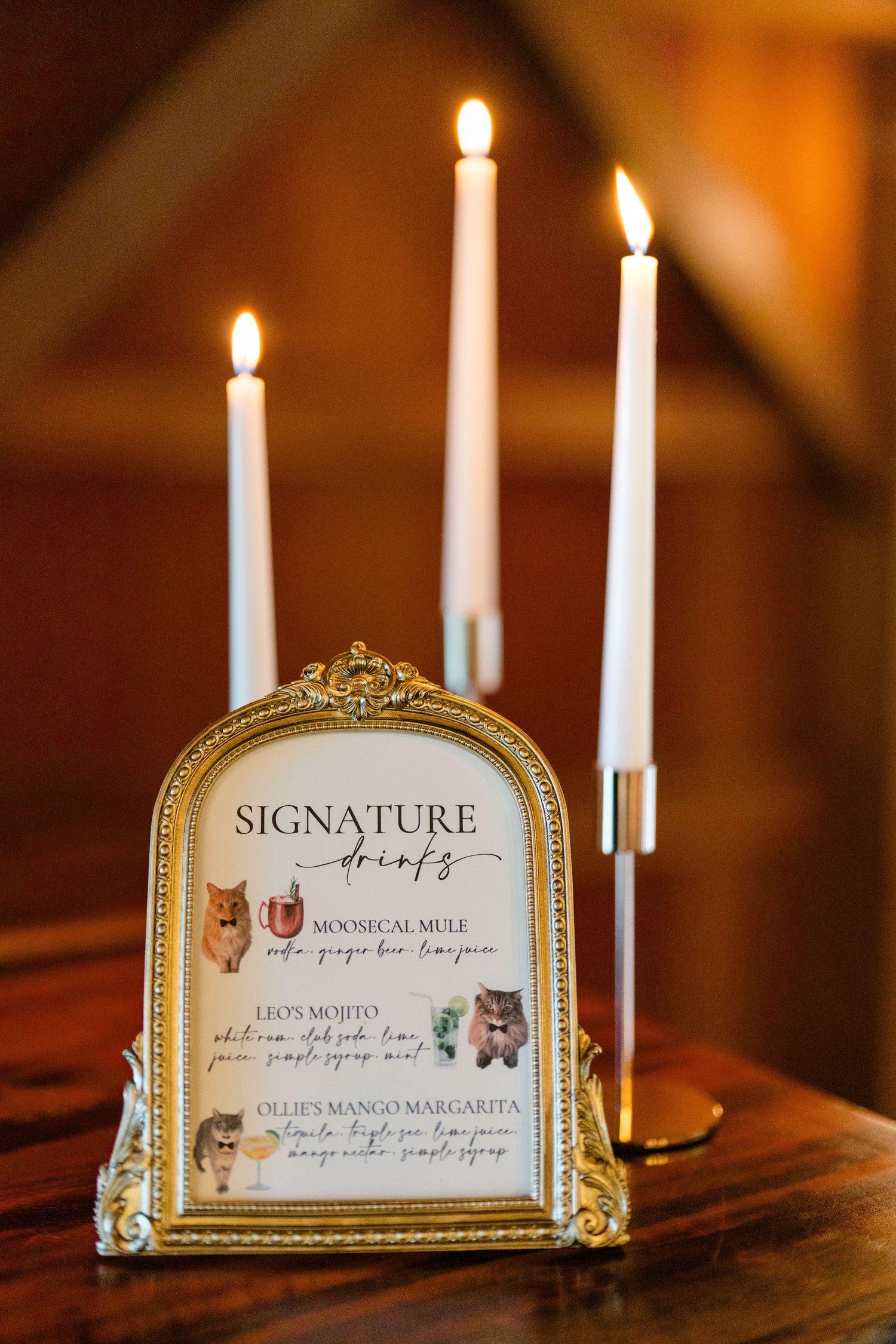 Elegant gold-framed wedding reception table cards with candles in an ornate display.