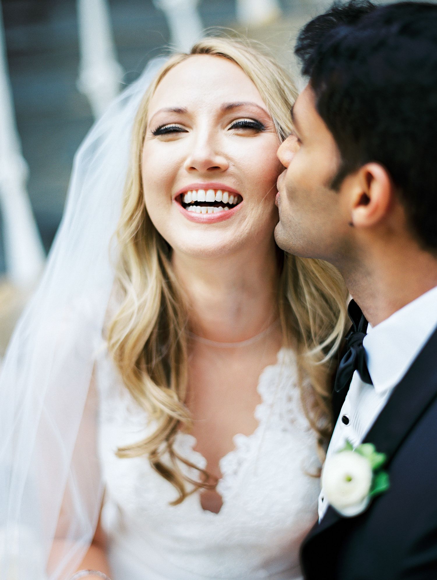 A tender moment shared between newlyweds wearing classic white gown and black tuxedo.