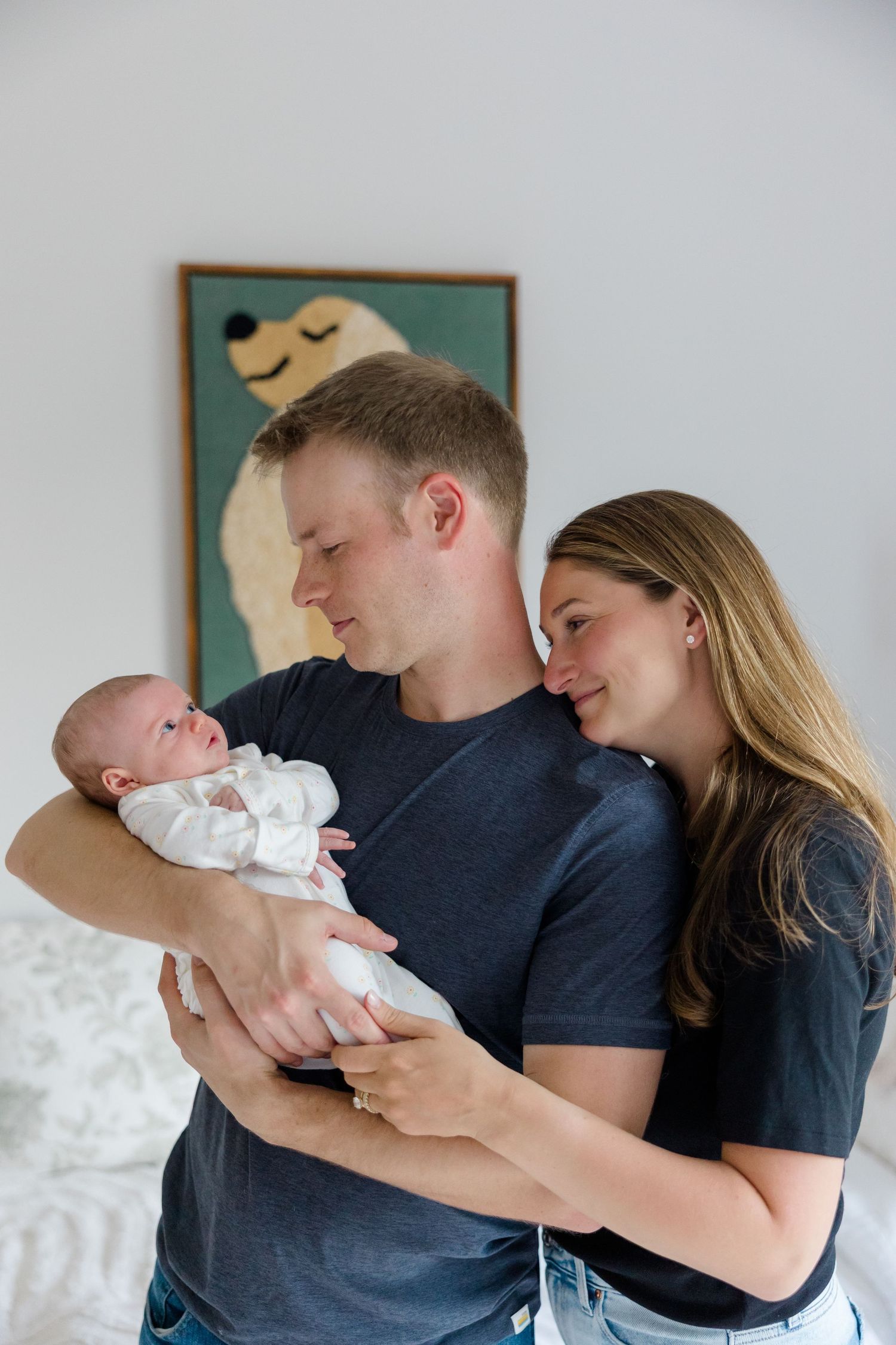 New parents sharing tender moments with their newborn in a cozy home setting.