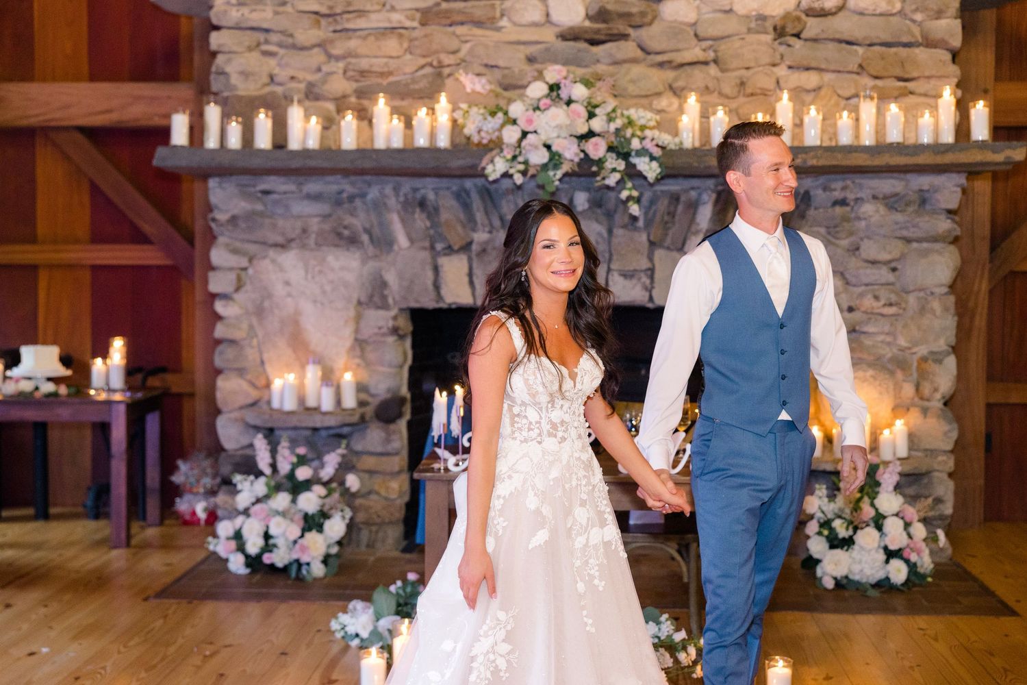 Wedding reception venue with rustic stone walls and elegant white floral arrangements.
