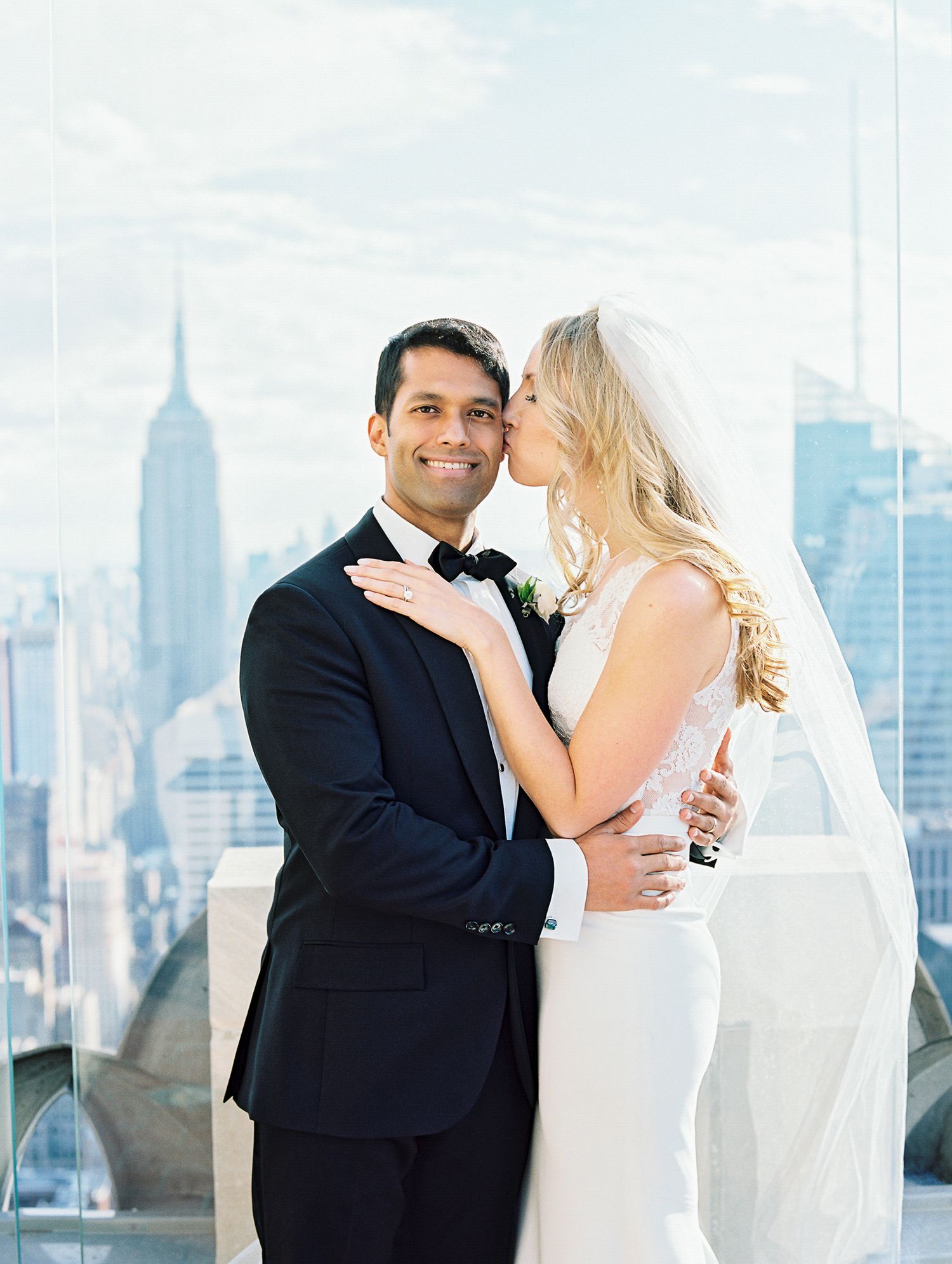 Elegant wedding portrait with Empire State Building visible in NYC skyline background.