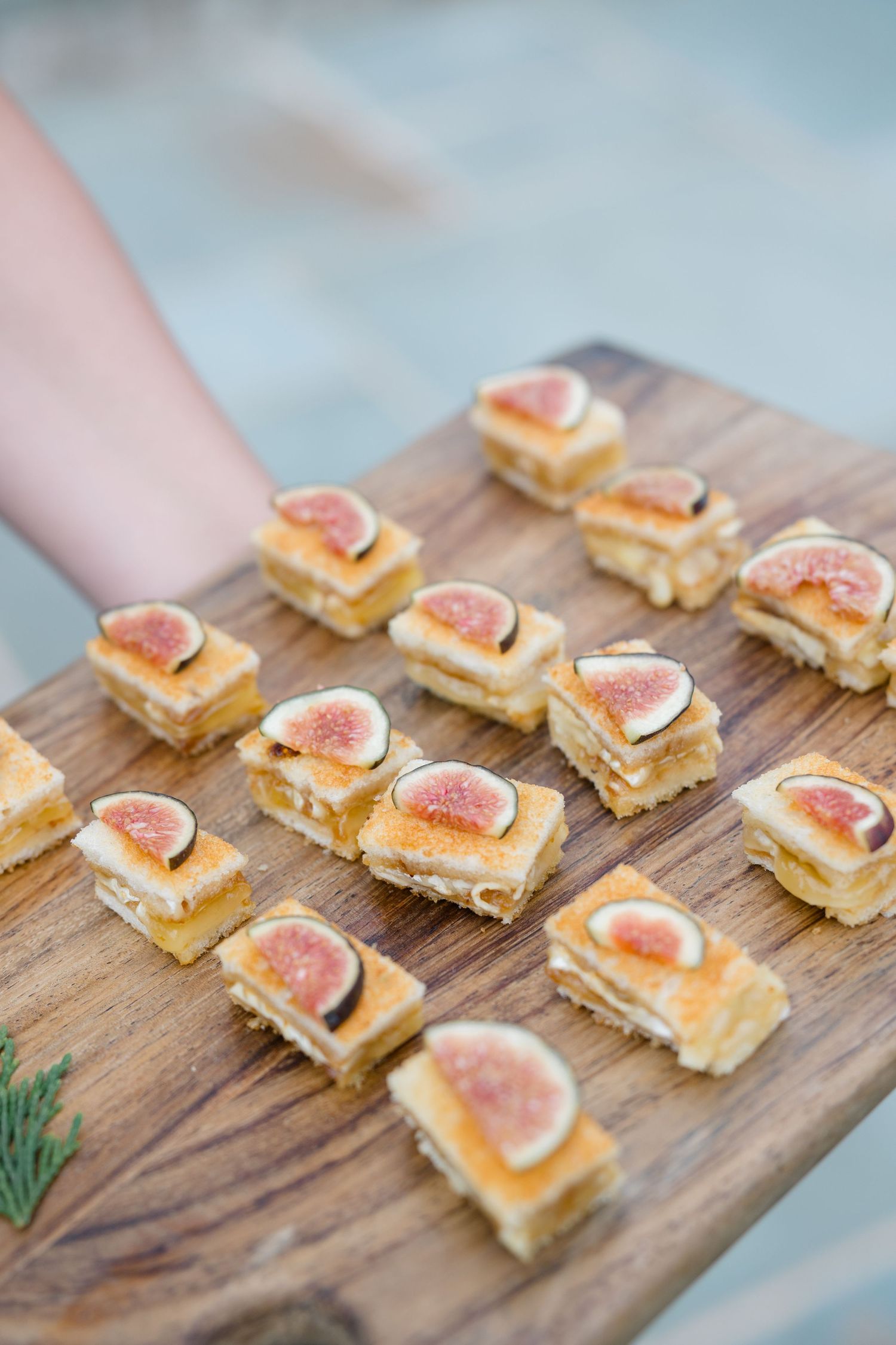 Elegant appetizers featuring fresh figs arranged on a rustic wooden serving board.