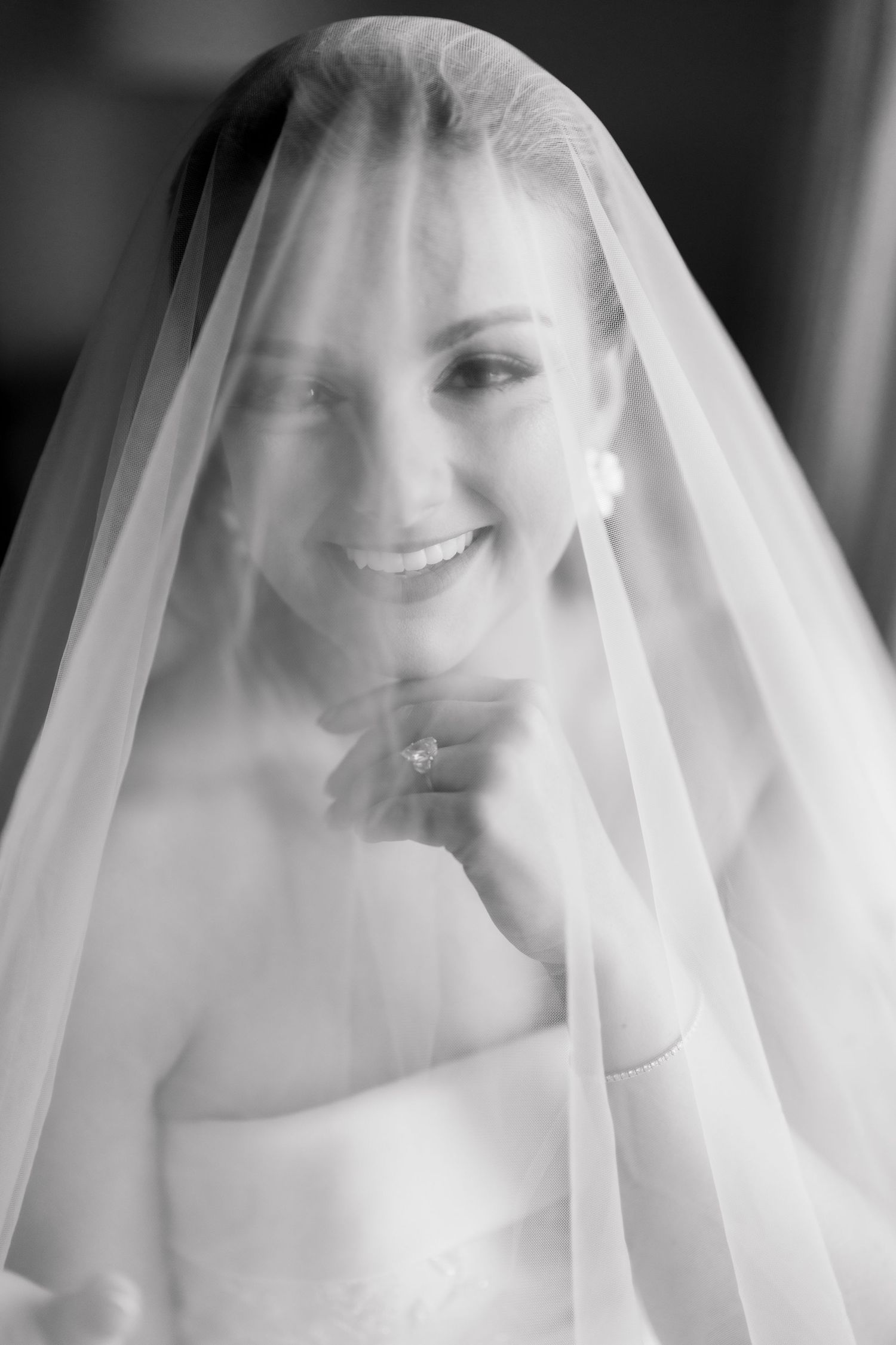 A bridal veil creates a soft, ethereal effect in this black and white wedding portrait series.