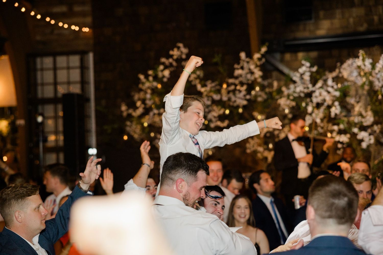 Energetic wedding celebration with dancing and crowd enthusiasm.