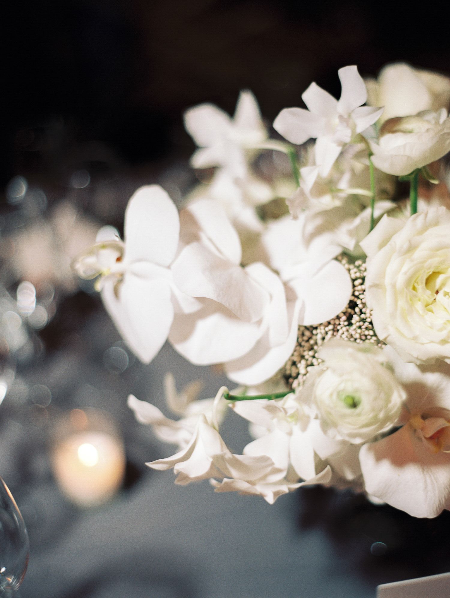 Delicate white roses and flowers in a soft focus arrangement with bokeh lighting effects.