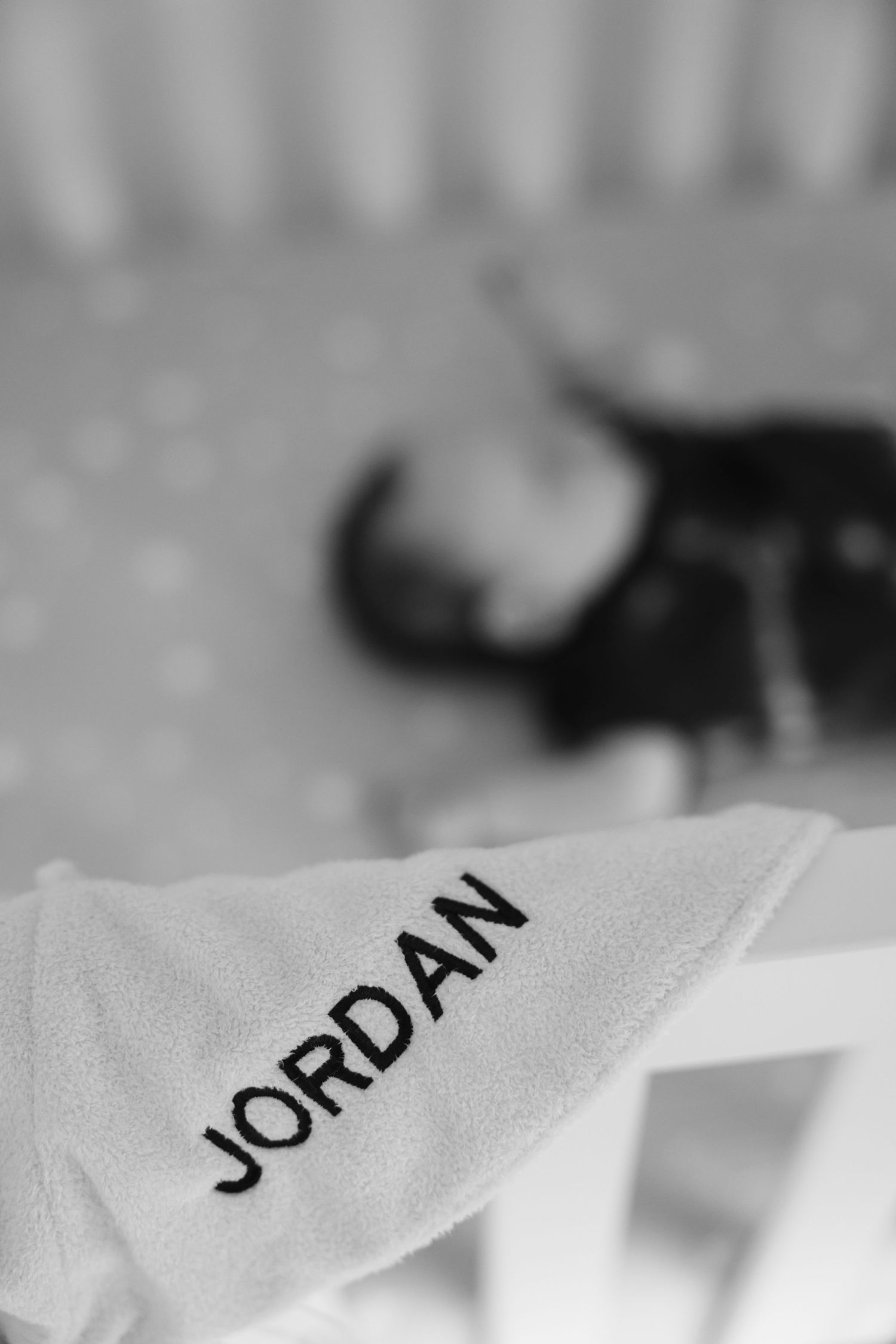 A close-up black and white photograph showing text that reads 'JORDAN' on a light colored fabric.