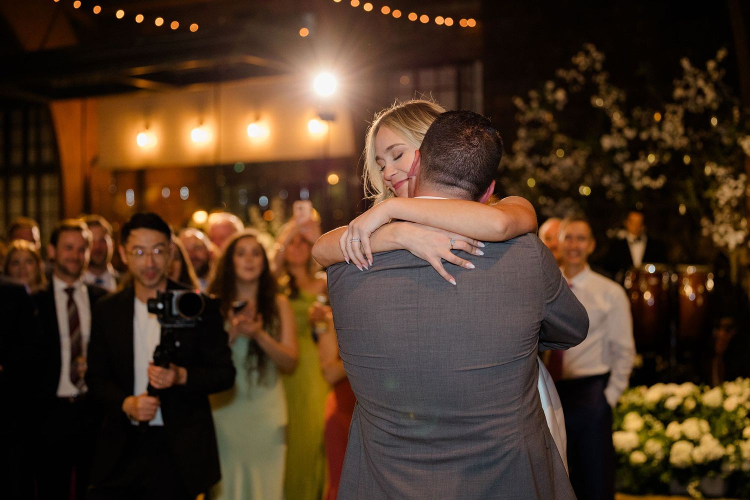 Intimate first dance moment at an evening wedding reception with string lights.