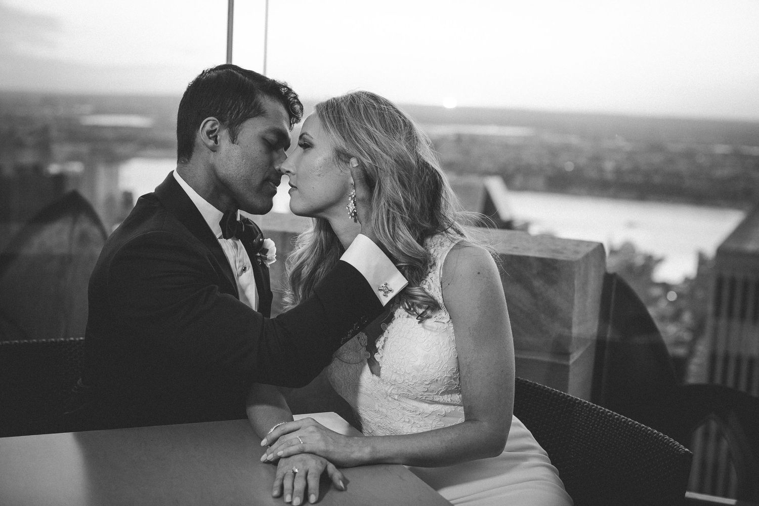 A romantic black and white wedding portrait captured on a scenic overlook.