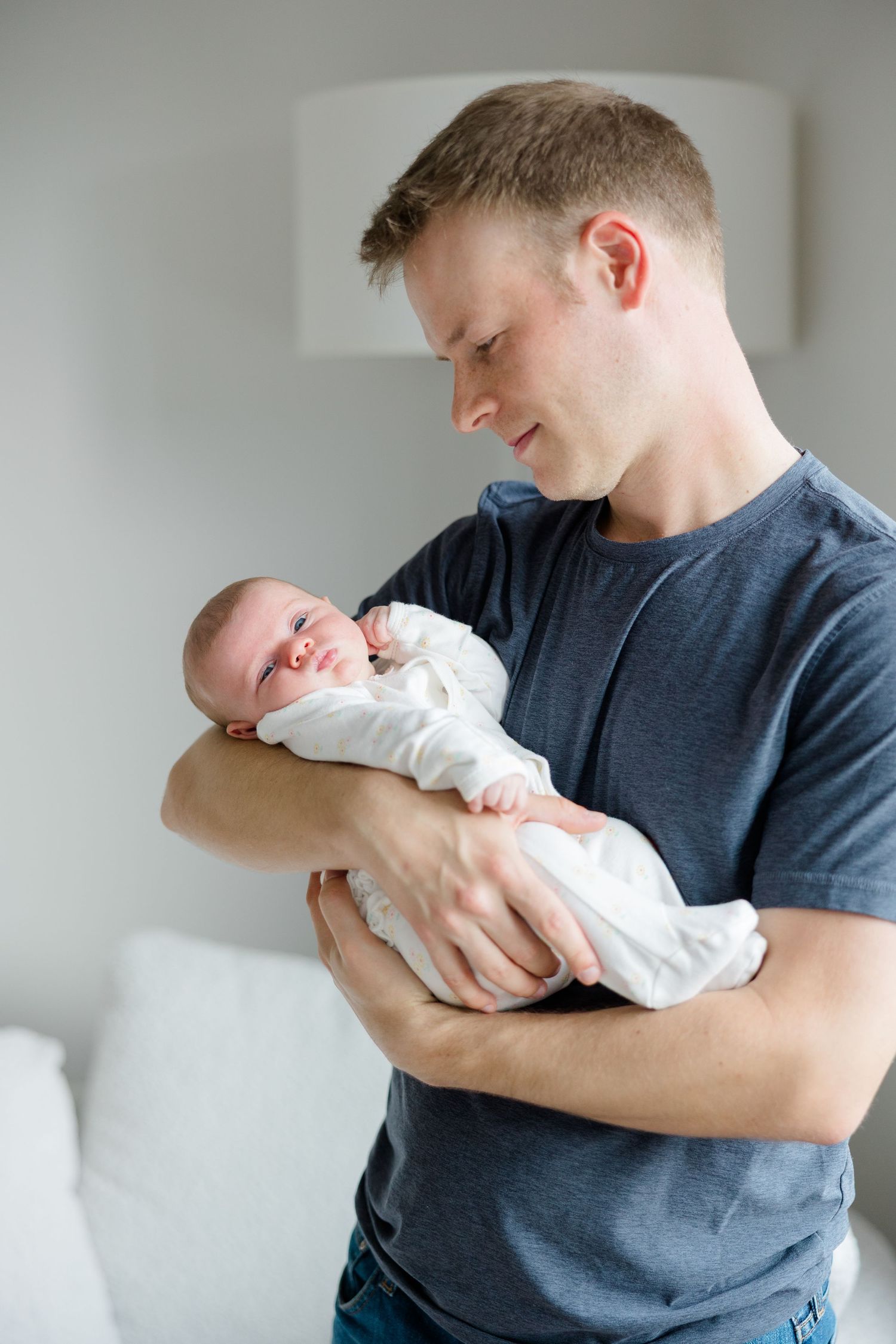 A joyful moment shared with a smiling baby wrapped in white.