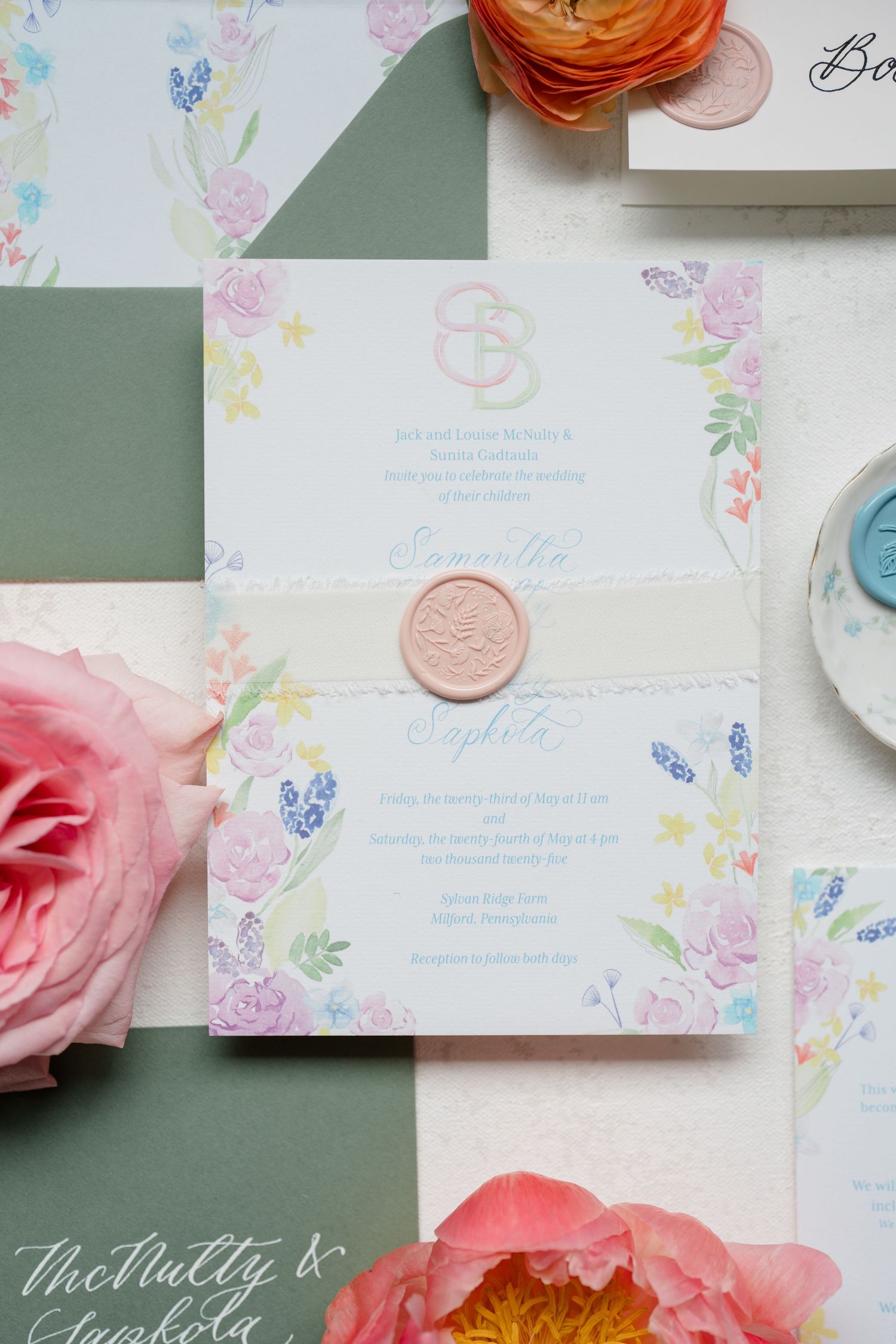 Delicate wedding invitation with pink wax seal, watercolor floral design, and elegant calligraphy on sage green background.