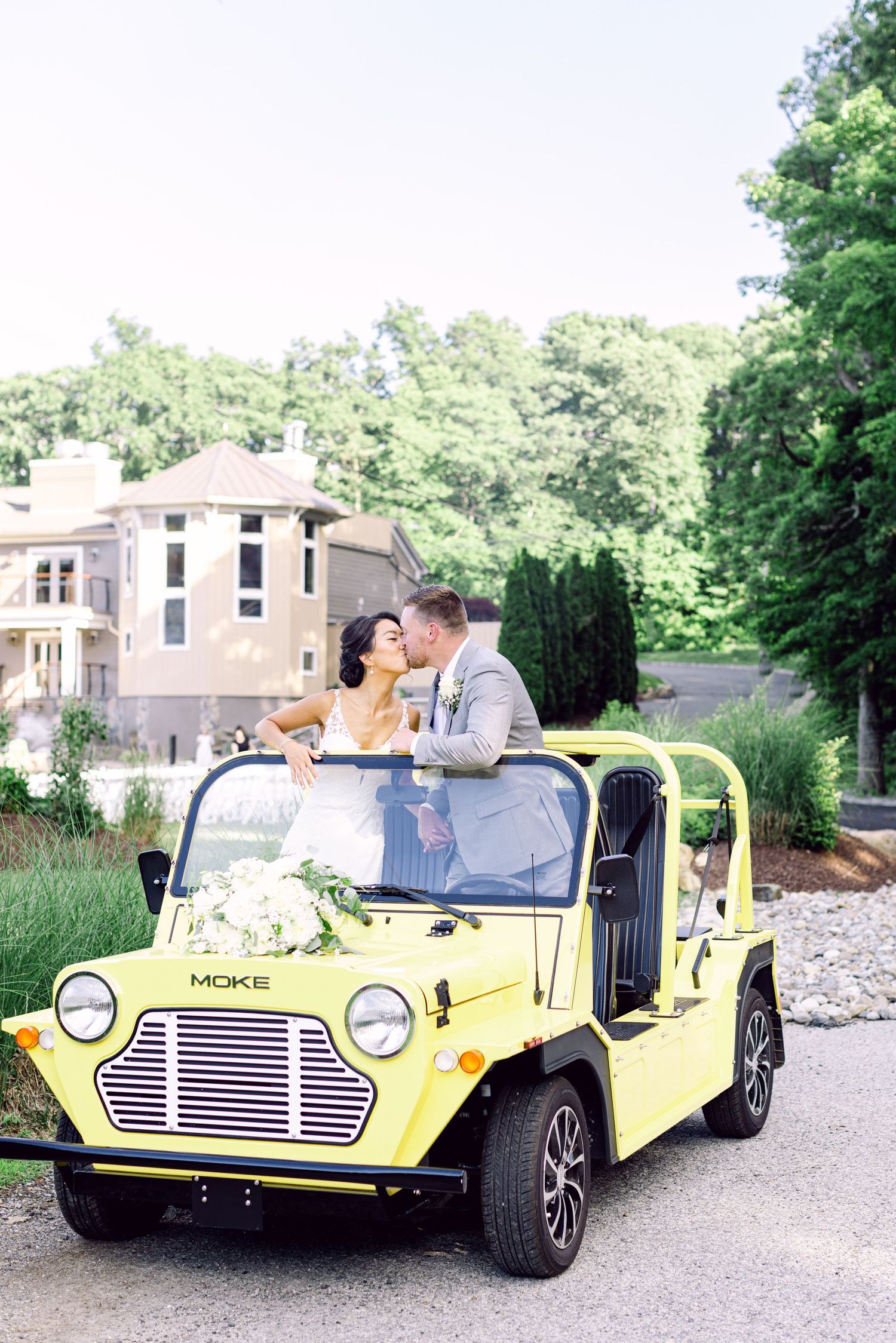 A retro yellow dune buggy vehicle is used for romantic wedding photos in an outdoor setting.