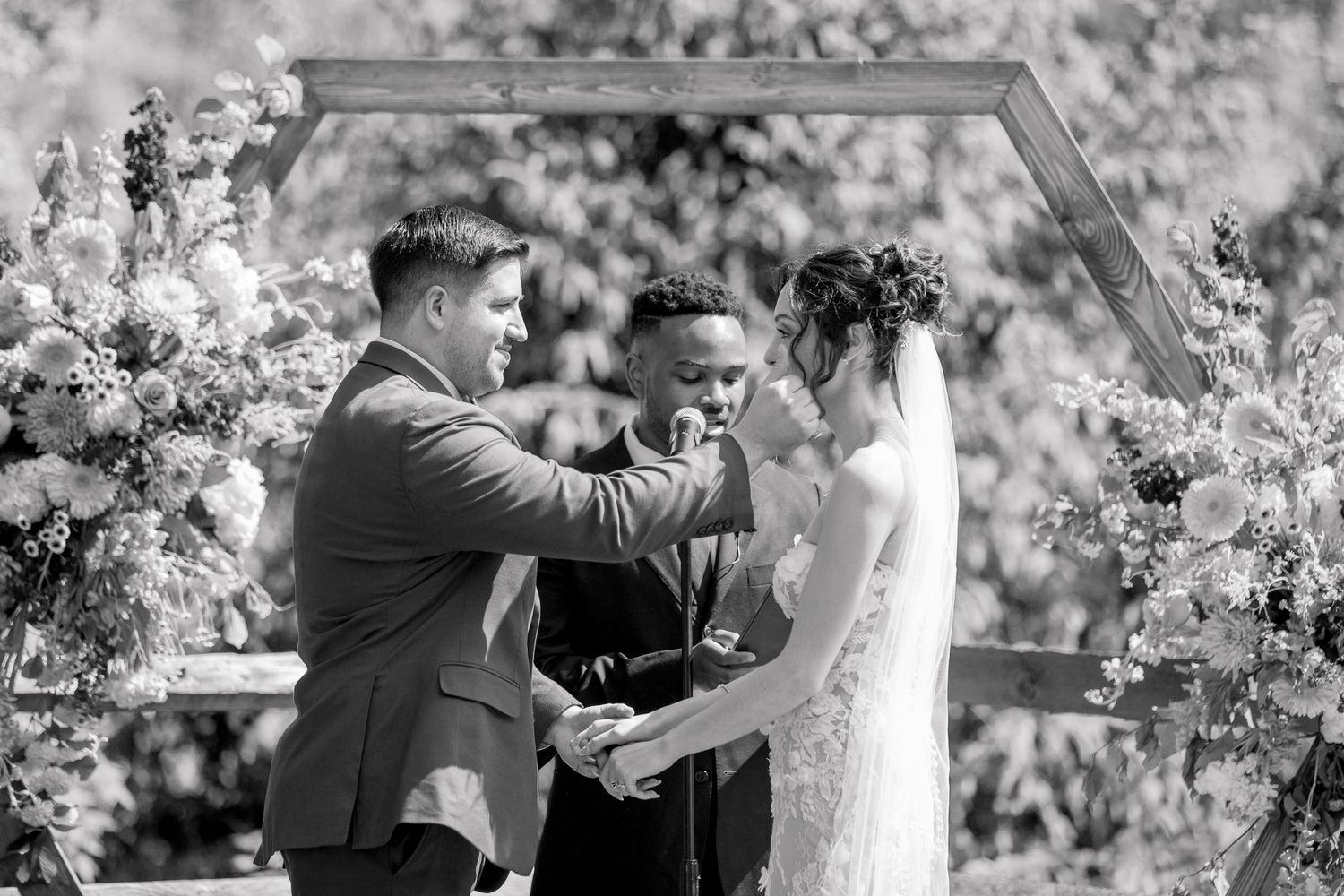 A sequence of five black and white photographs showing a wedding couple dancing together among blossoming trees.