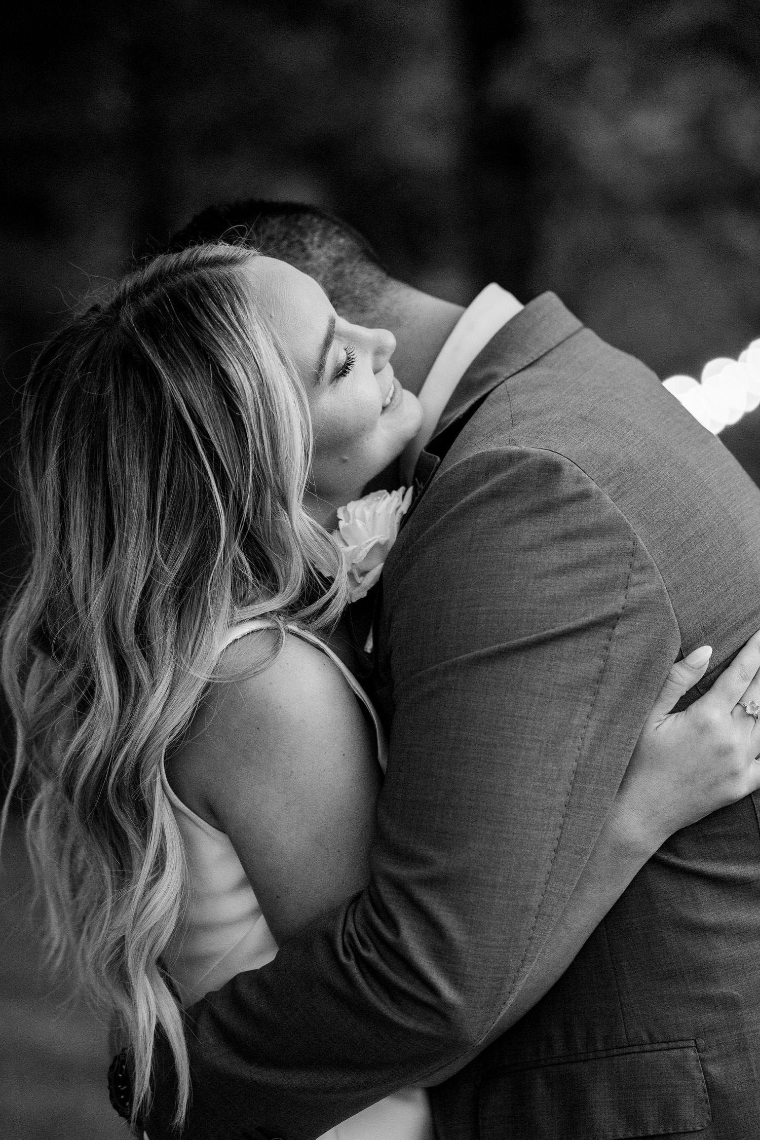 Black and white intimate portrait of couple embracing during their wedding photoshoot.
