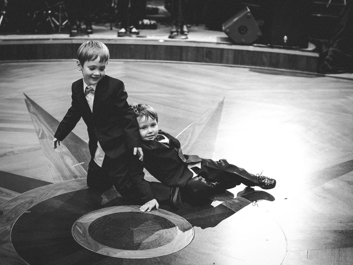 Vintage black and white photo of children playing on stage floor.
