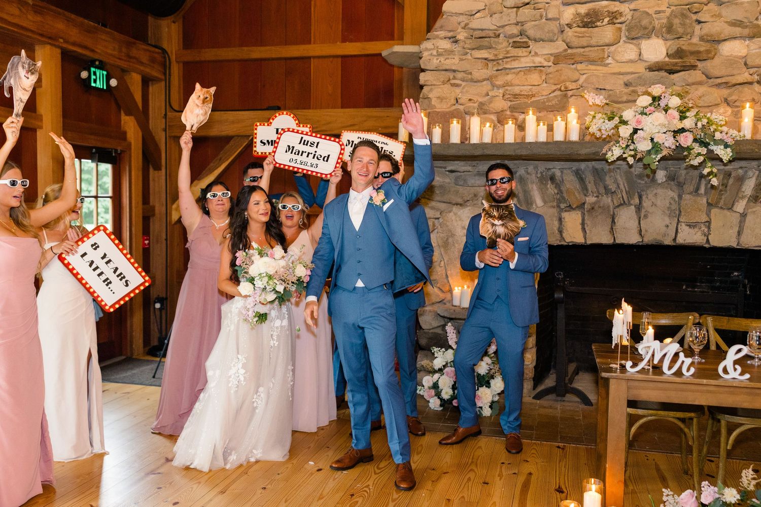 Wedding reception celebration in a rustic wooden barn venue with guests dancing and celebrating.