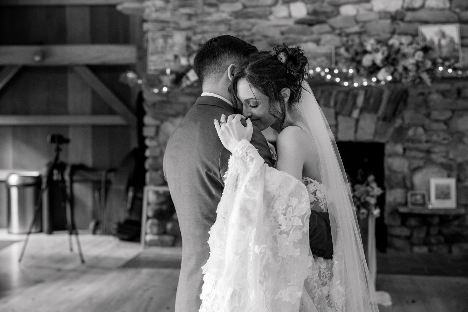 A romantic black and white wedding photo showing an intimate embrace on the dance floor.
