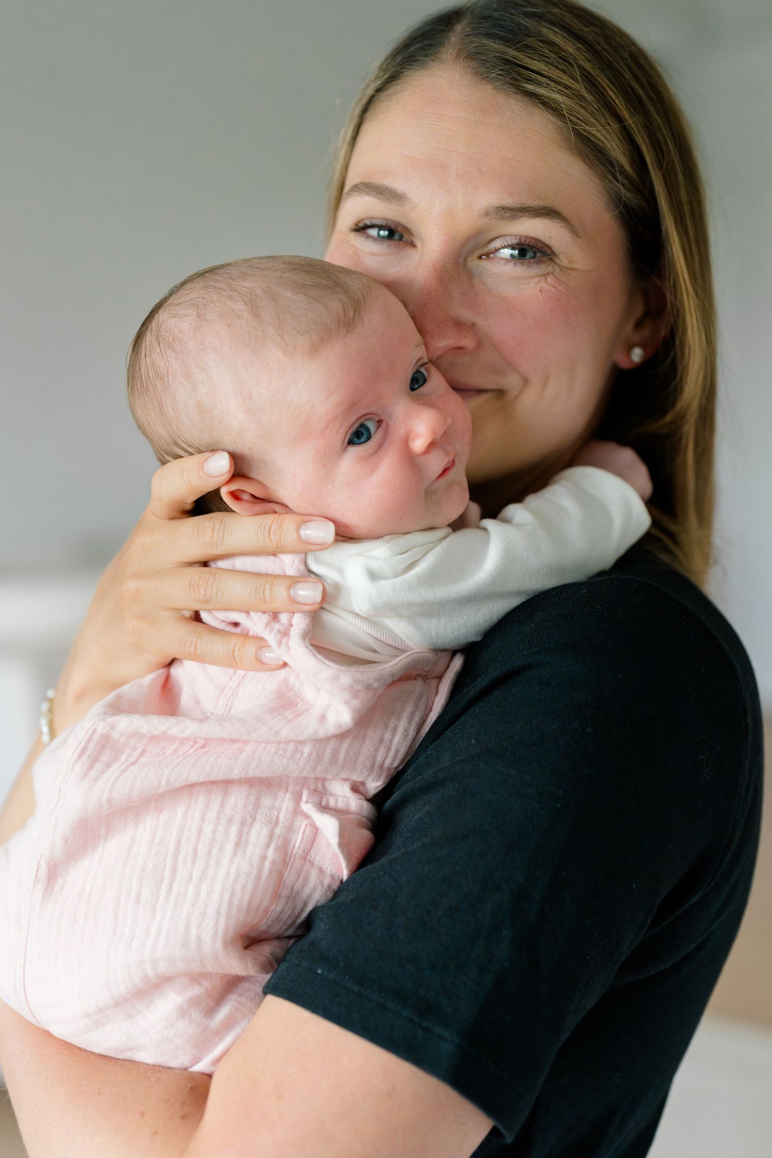 A tender moment of bonding with a baby wearing a pink outfit.