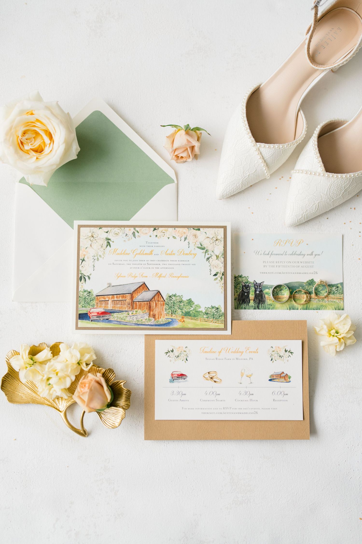 Elegant wedding invitation suite with watercolor barn design, sage green envelope, cream heels, and yellow roses on white background.